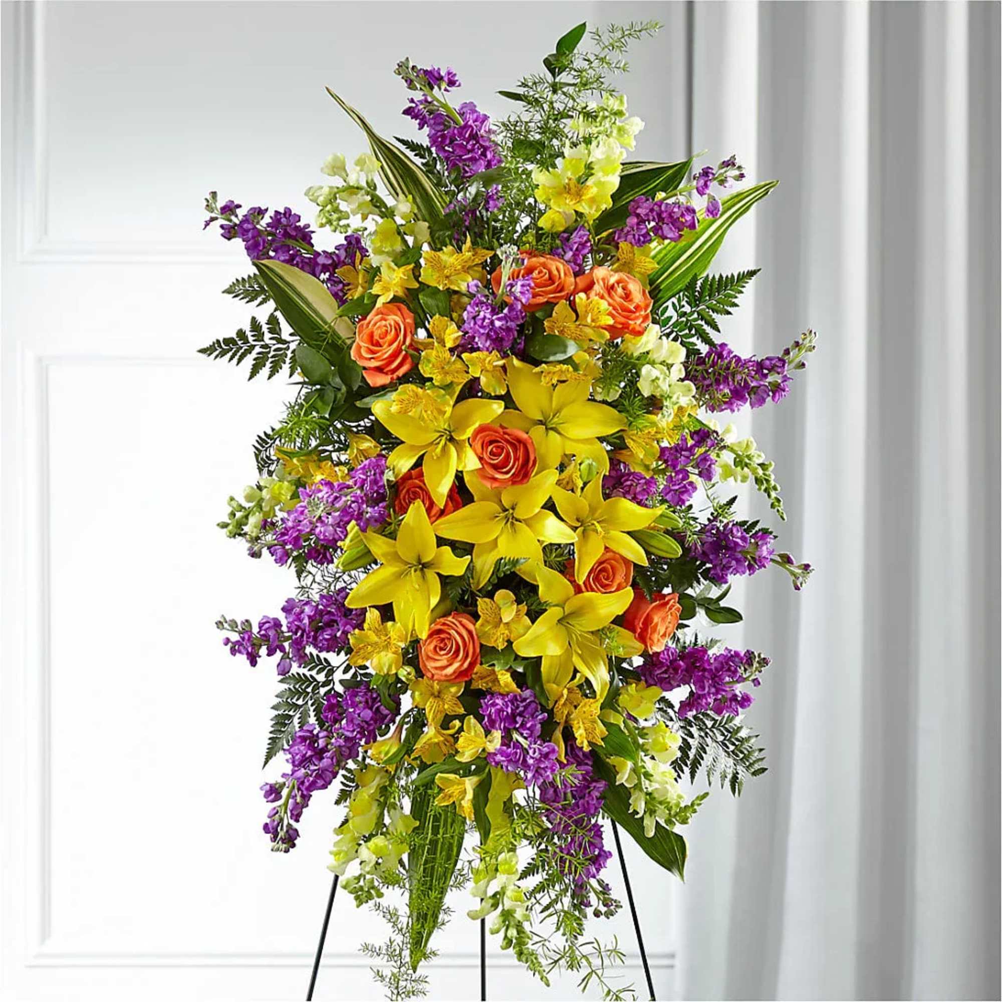 Tall floral spray with yellow lilies, orange roses, and purple blooms