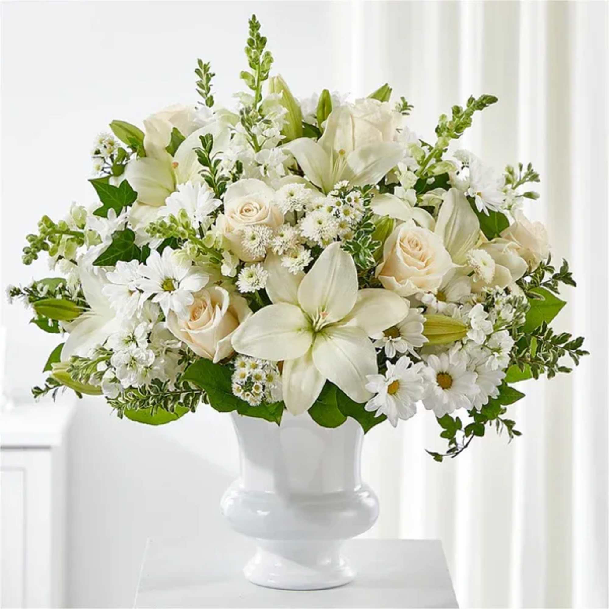 White floral arrangement in a white pedestal vase