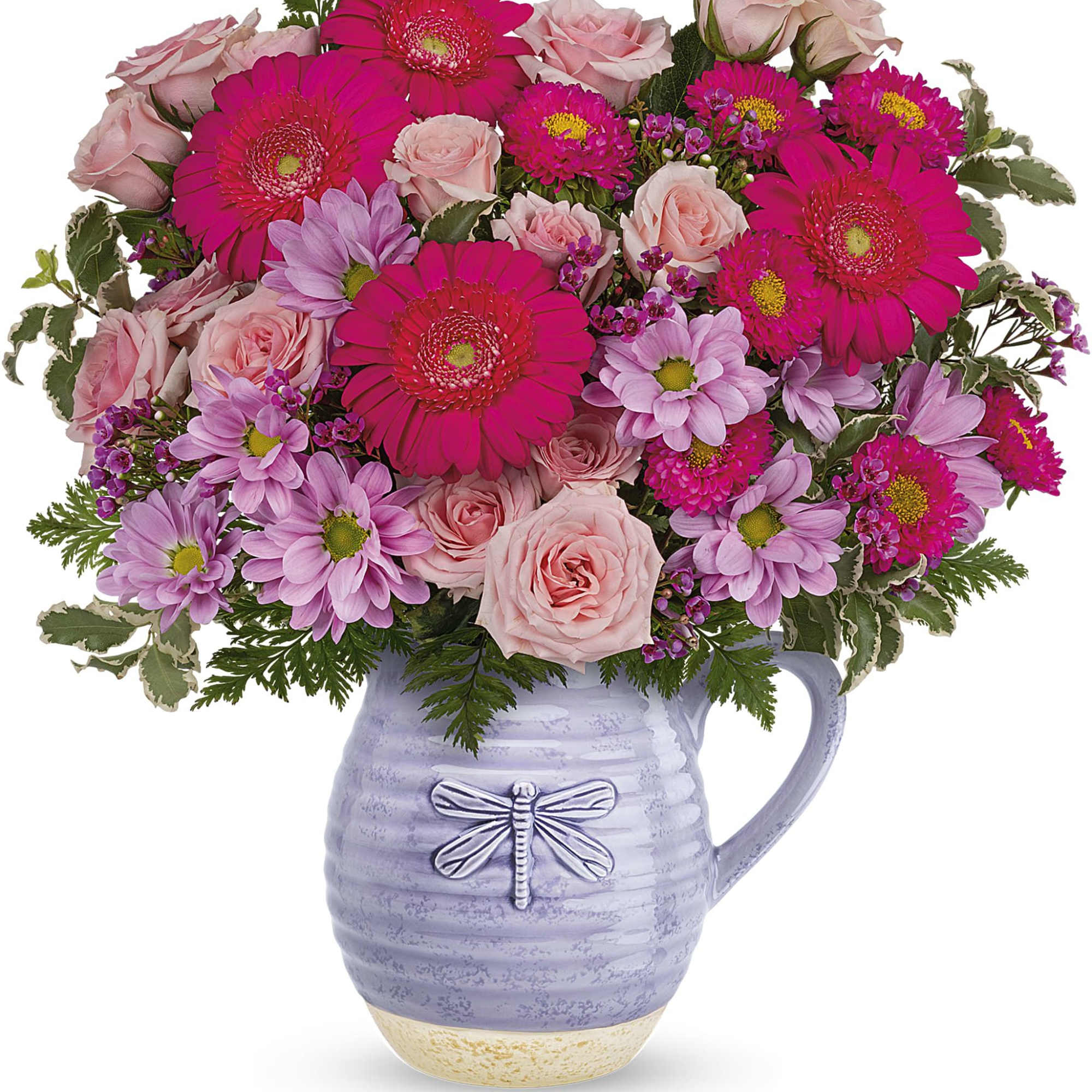Pink roses and bright gerbera daisies arranged in a lavender pitcher vase