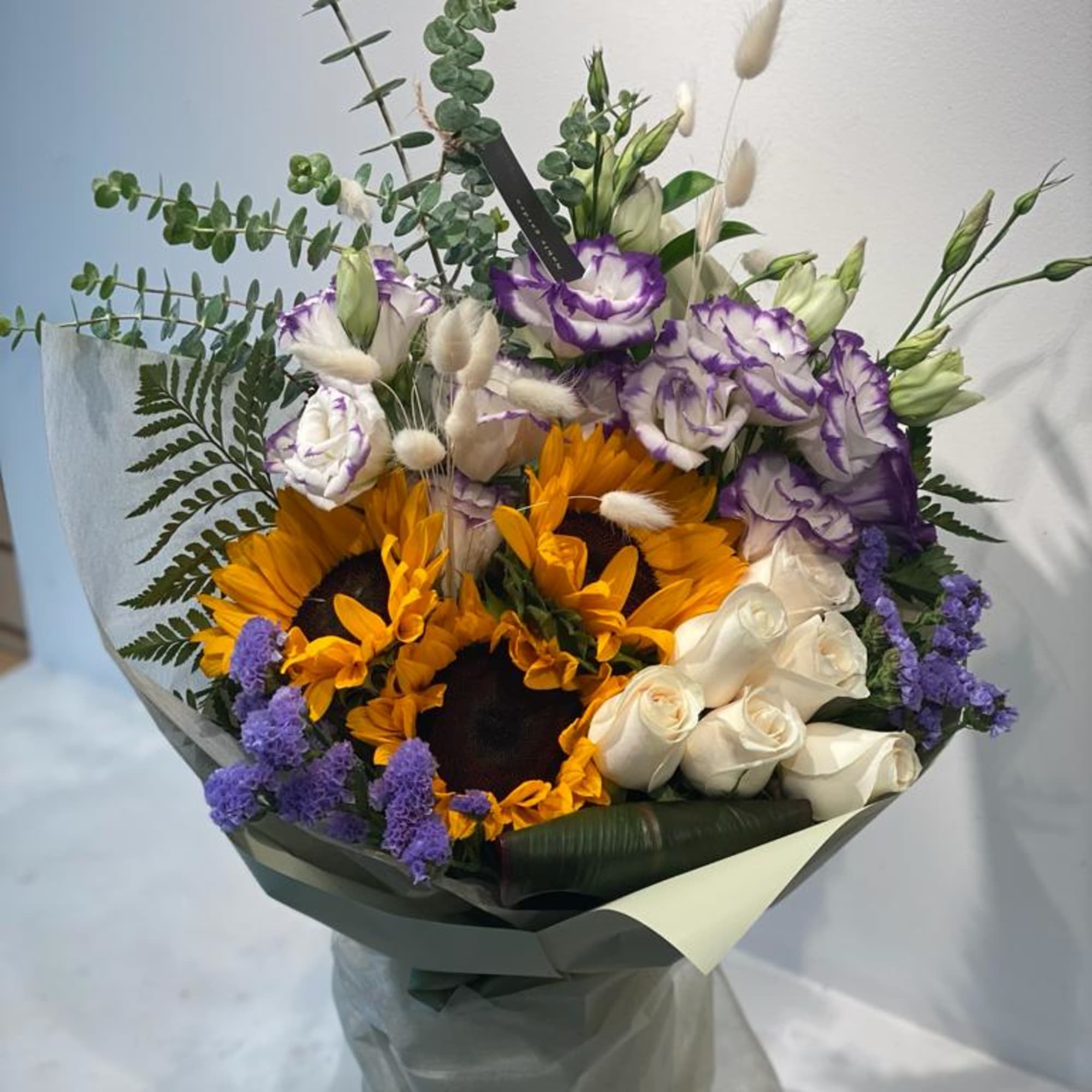 Bouquet with sunflowers, white roses, and purple-edged lisianthus