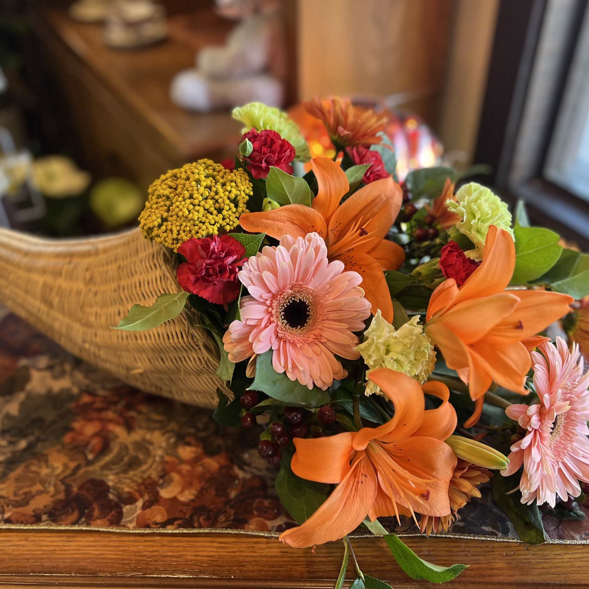 Orange asiatic lilies paired with soft pink gerber daisies, green carnations, yarrow, photo 2 of 2