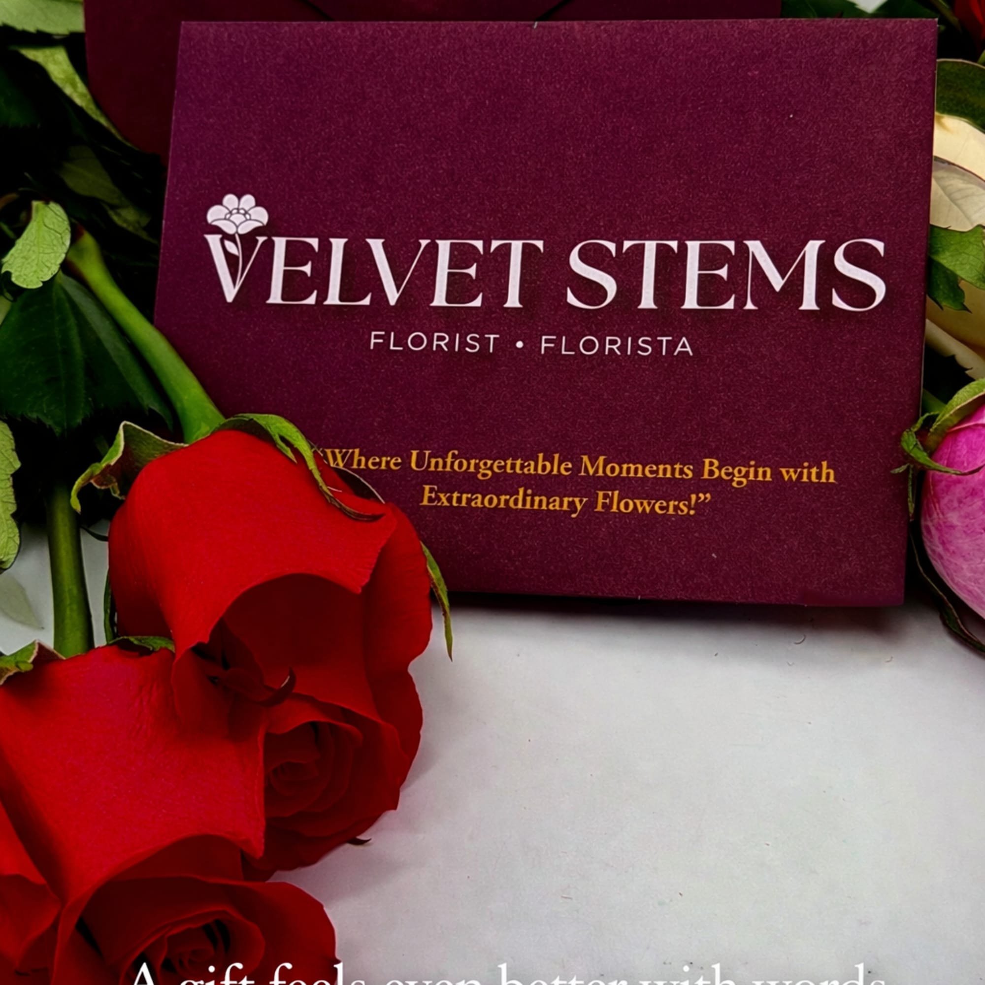 Burgundy Velvet Stems stationery card and envelope with red roses beside them.
