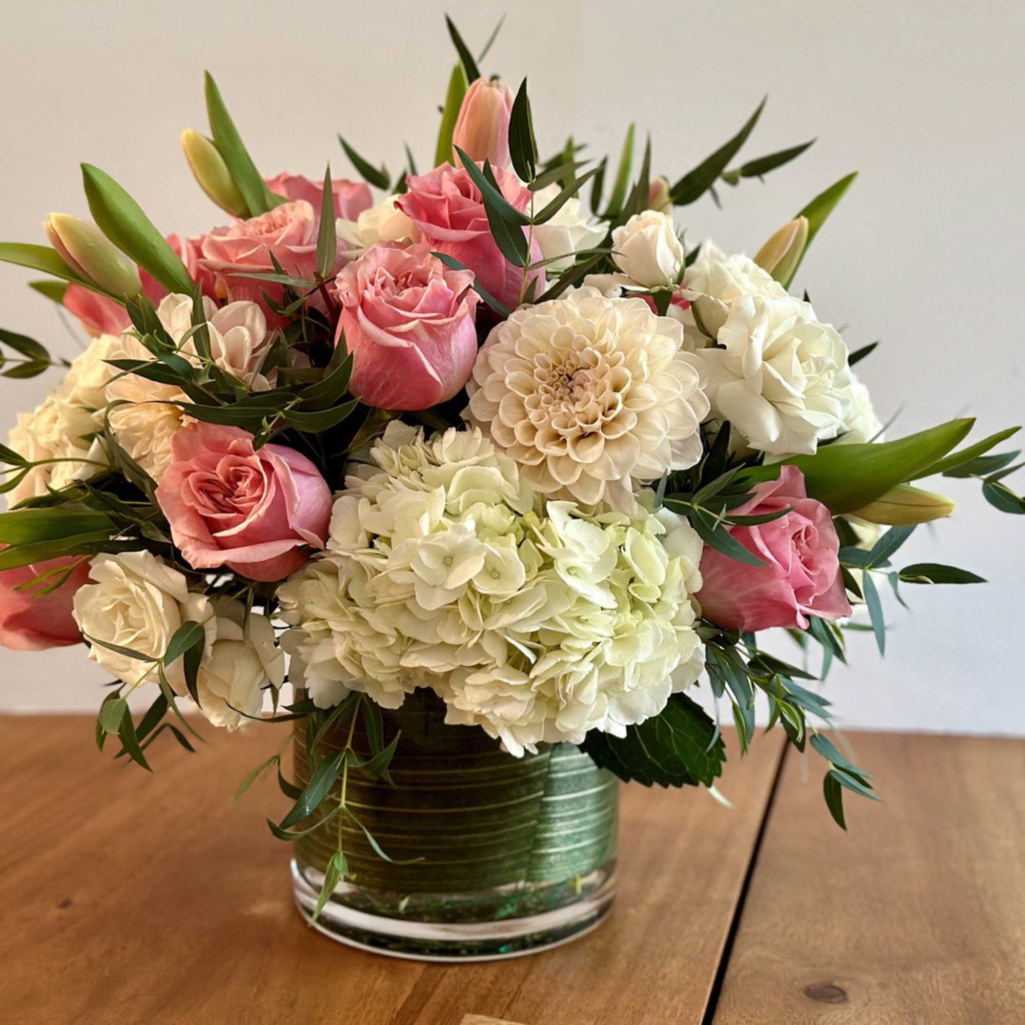 Pink roses and white hydrangeas arranged in a glass vase
