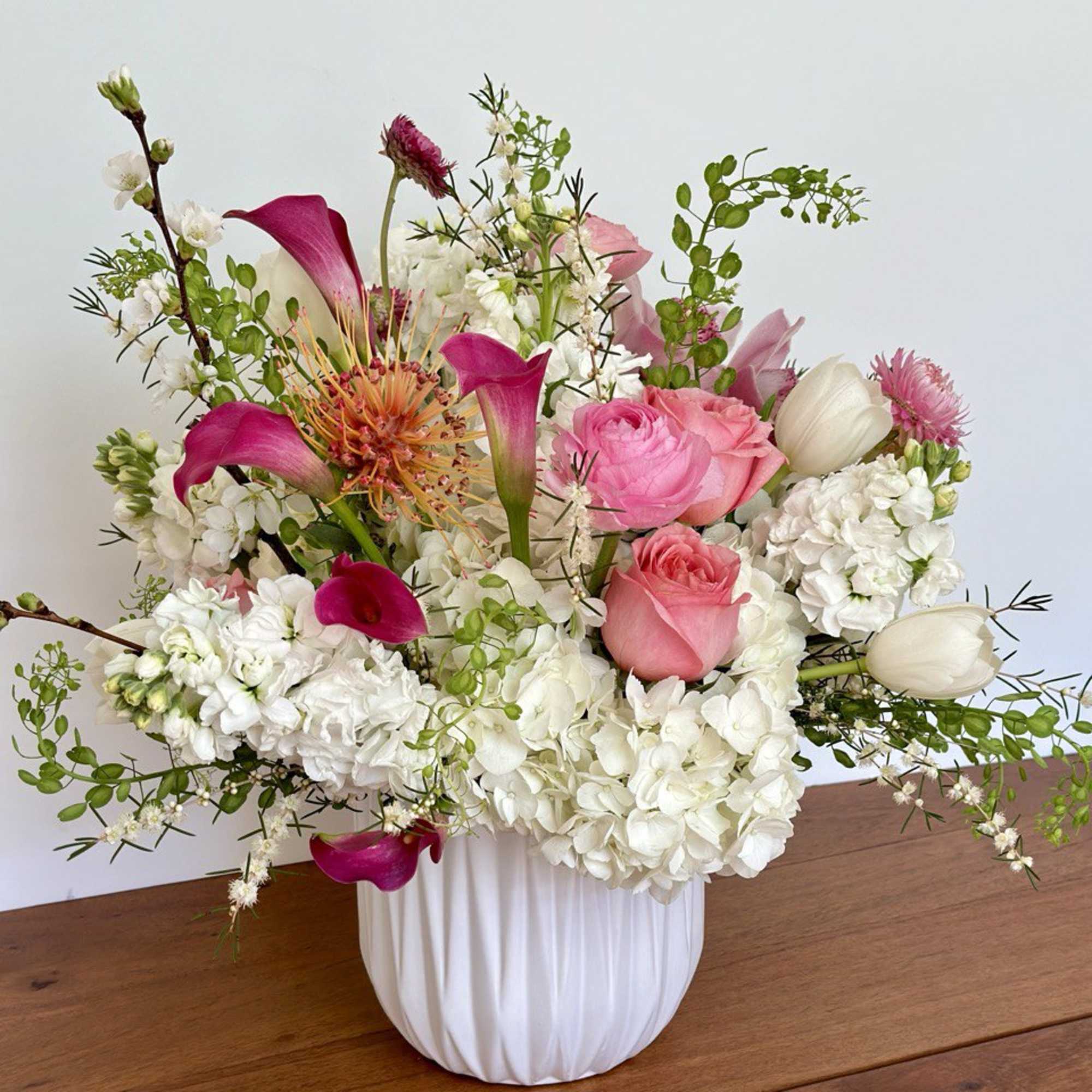 Pink and white floral arrangement in a white vase