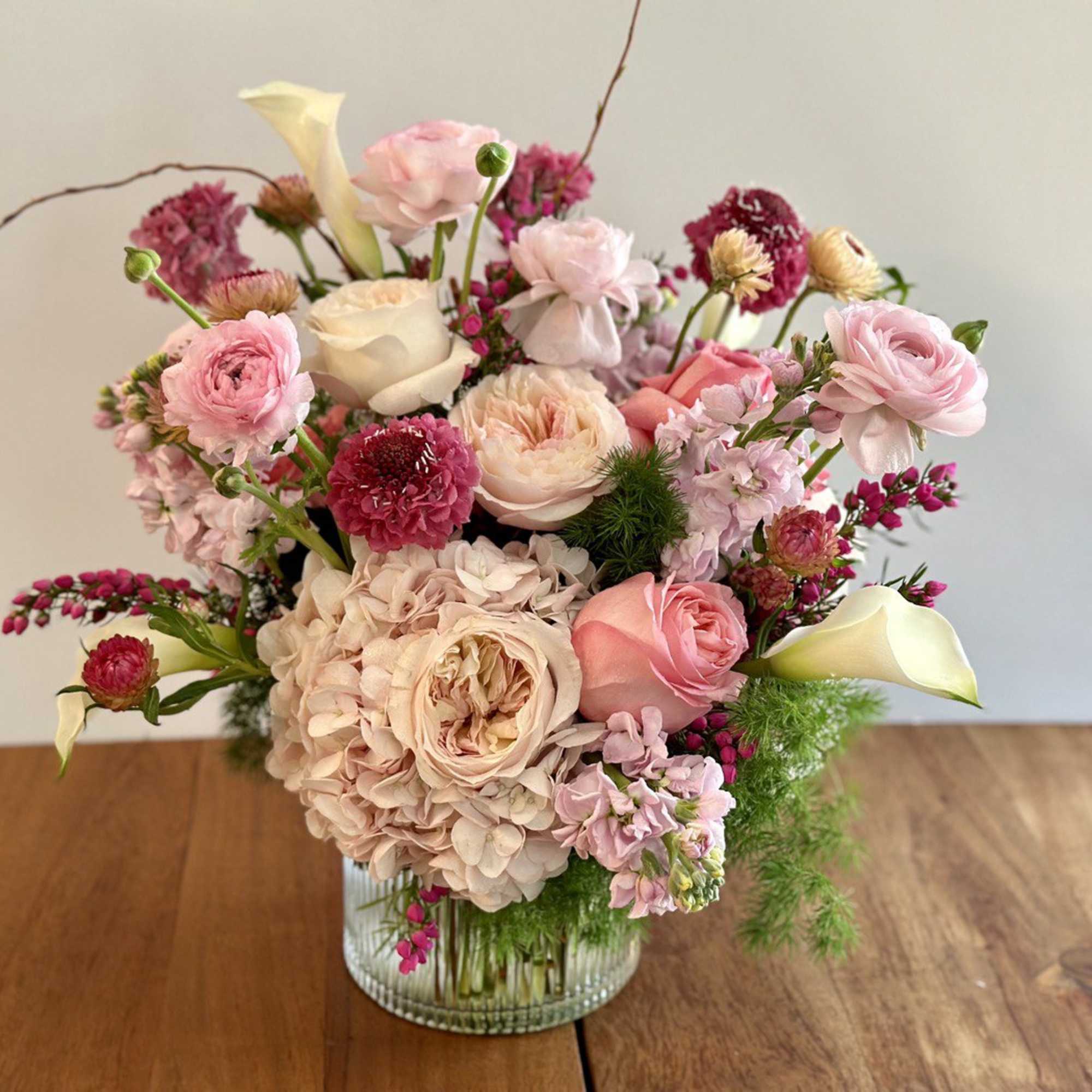 Pink and cream floral arrangement in a glass vase