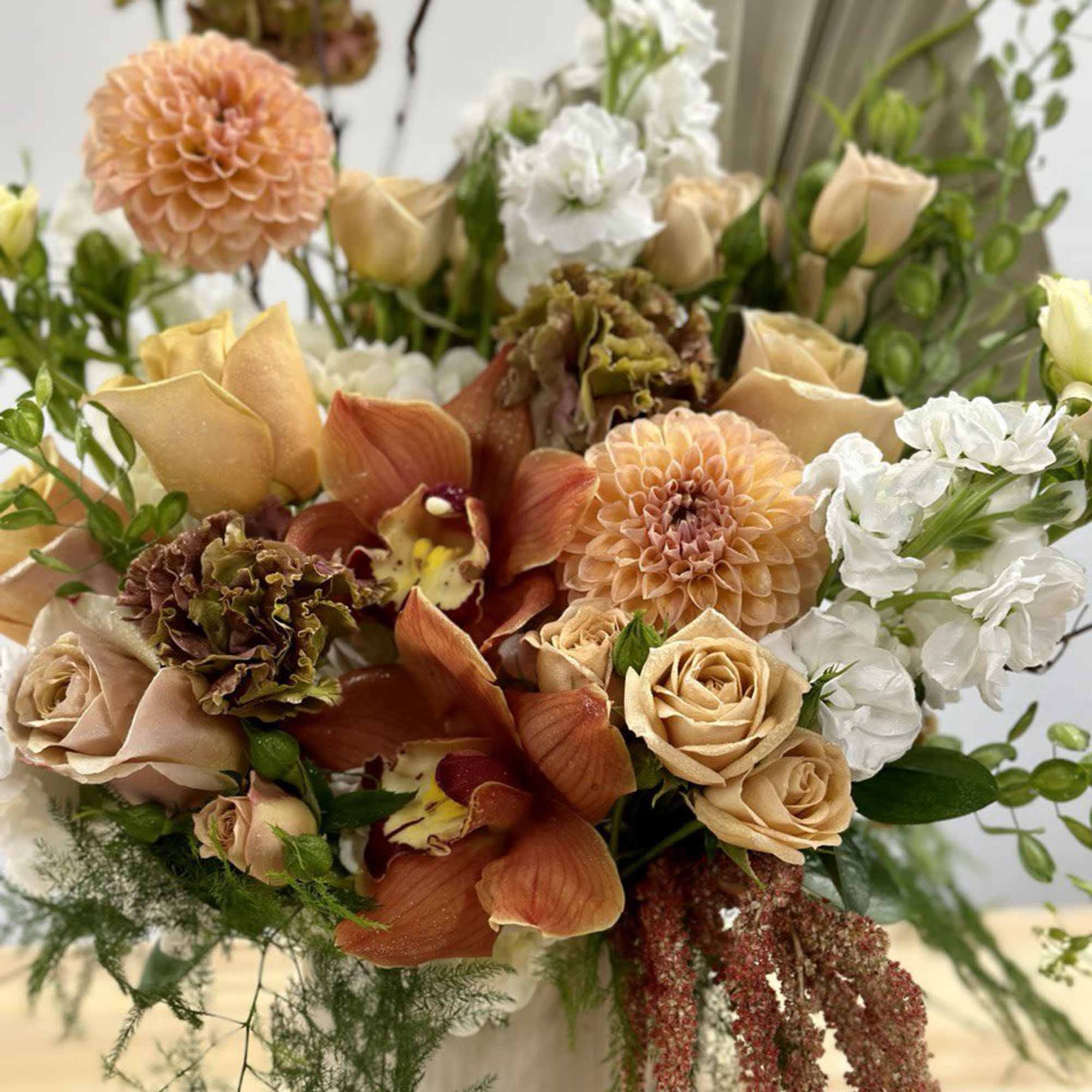 Mixed bouquet with peach, white, and orange flowers in a vase