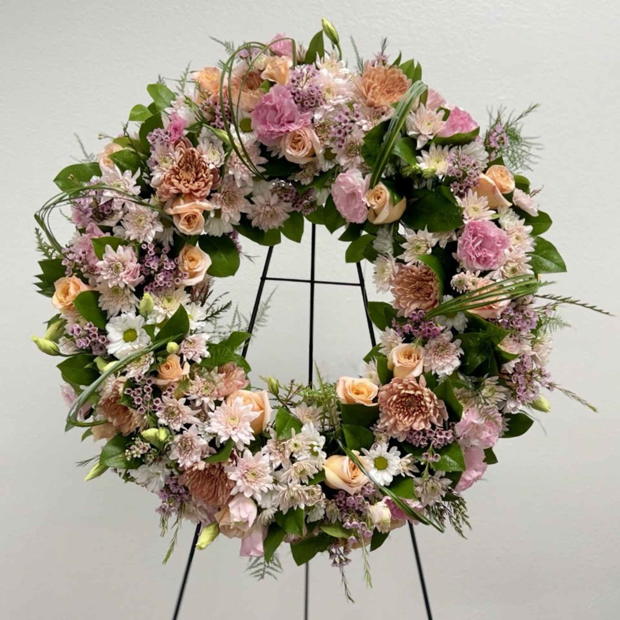 A beautiful white and green tribute wreath that calms, this easel arrangement