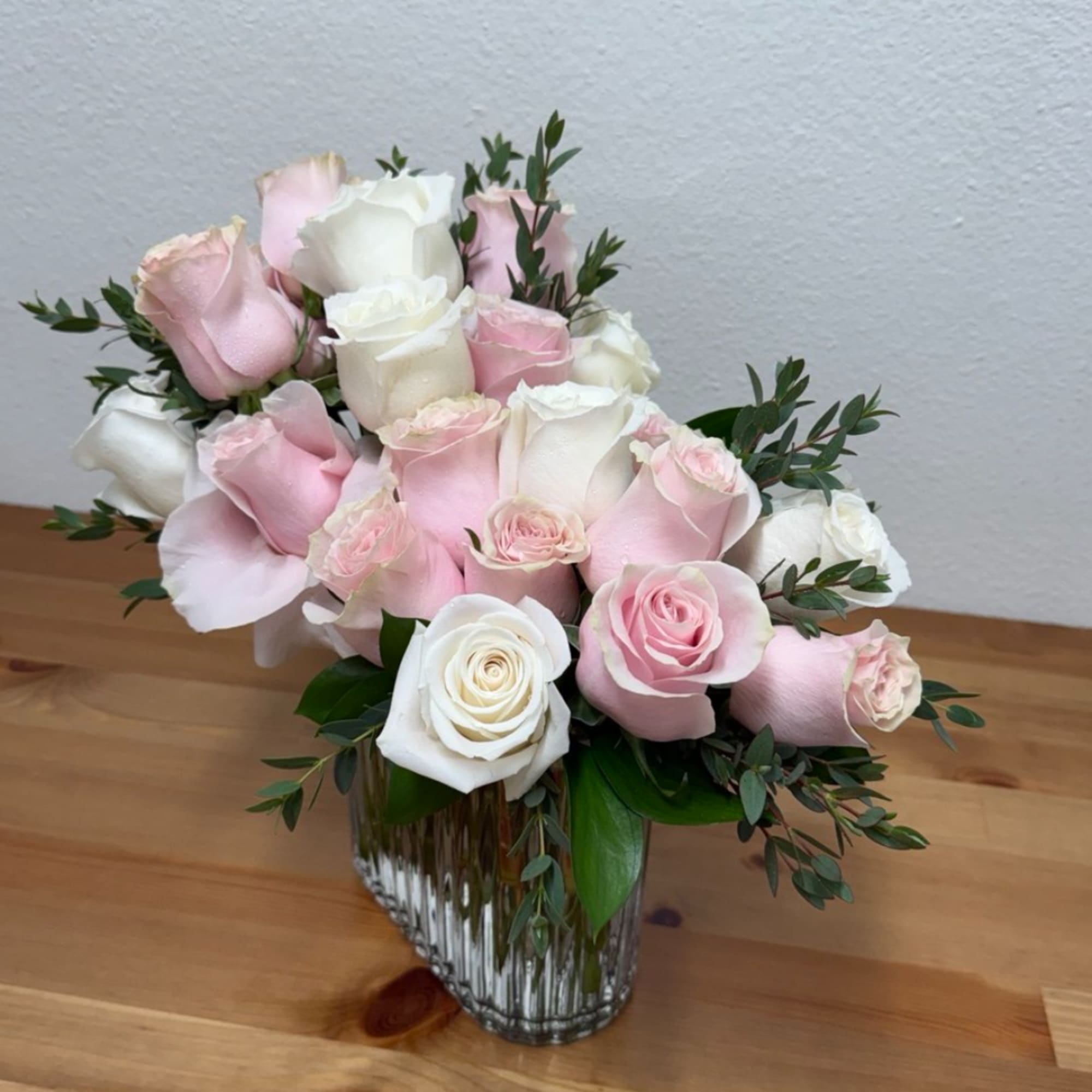 Pink and white roses arranged in a clear glass vase, photo 3 of 3