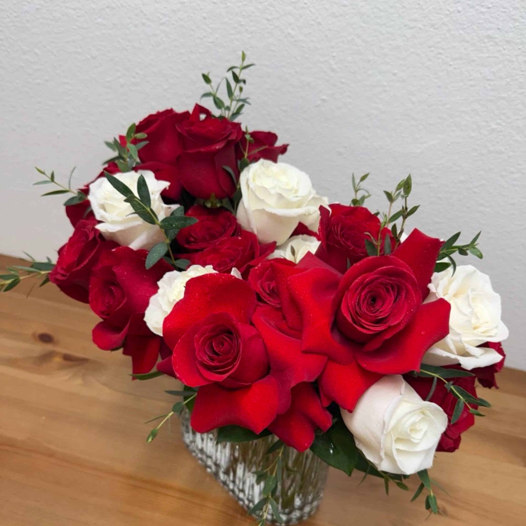 Red and white roses arranged in a clear glass vase, photo 2 of 3