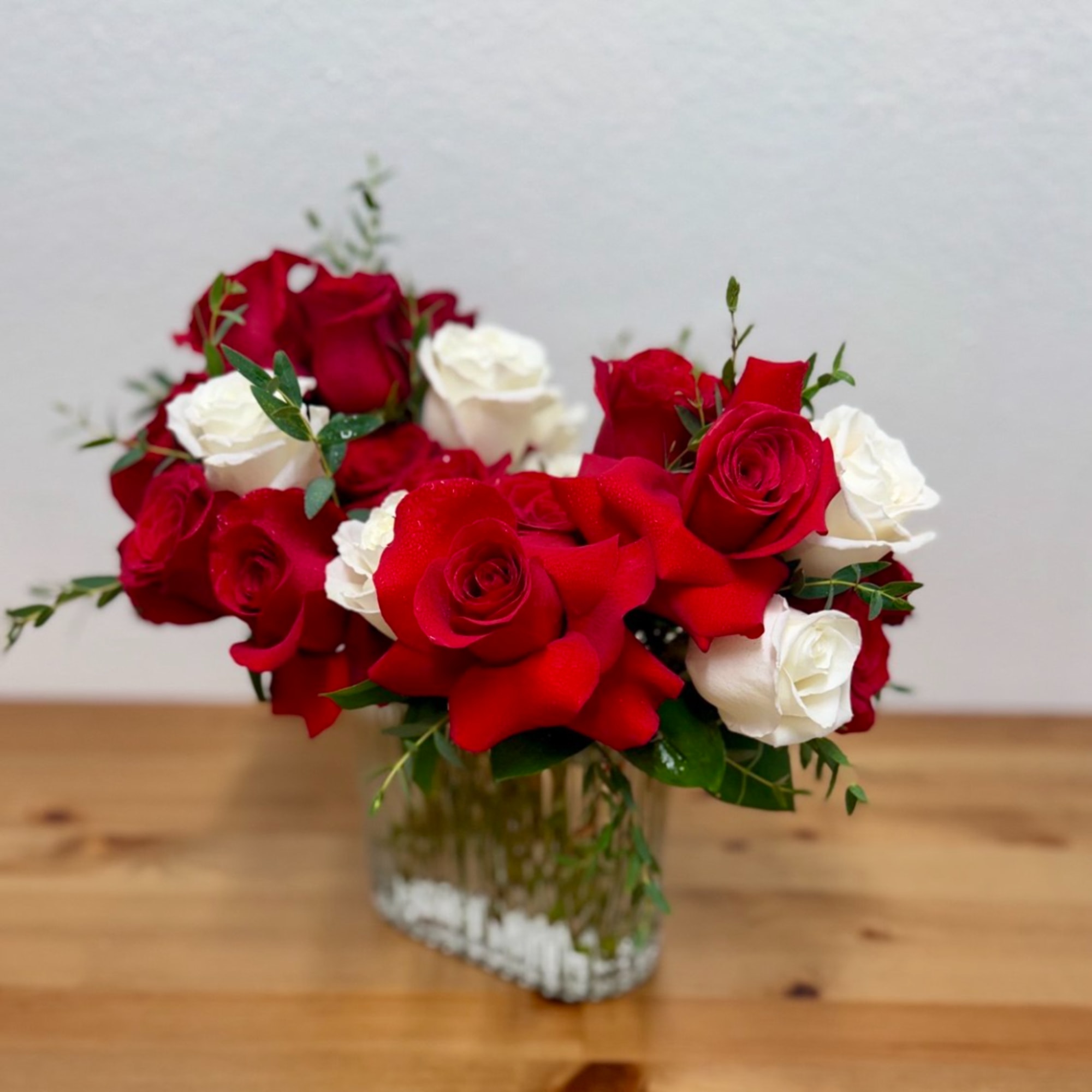 Red and white roses arranged in a clear glass vase, photo 3 of 3