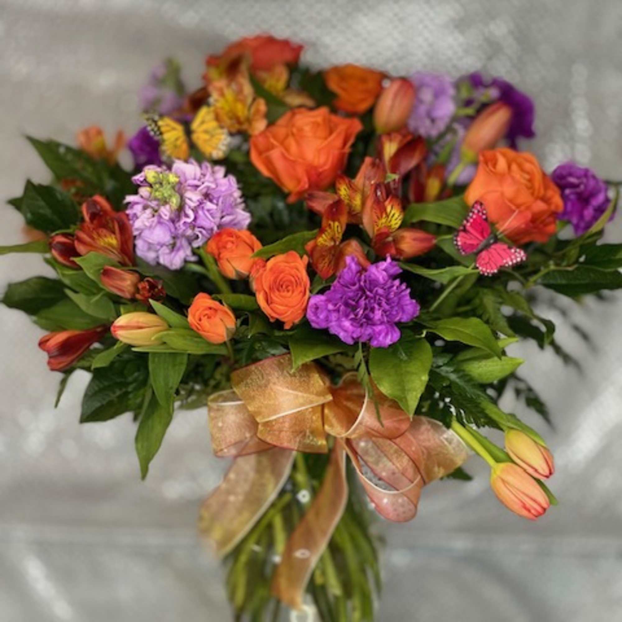 Assorted flowers in shades of purple and orange, with a butterfly touch, photo 2 of 2