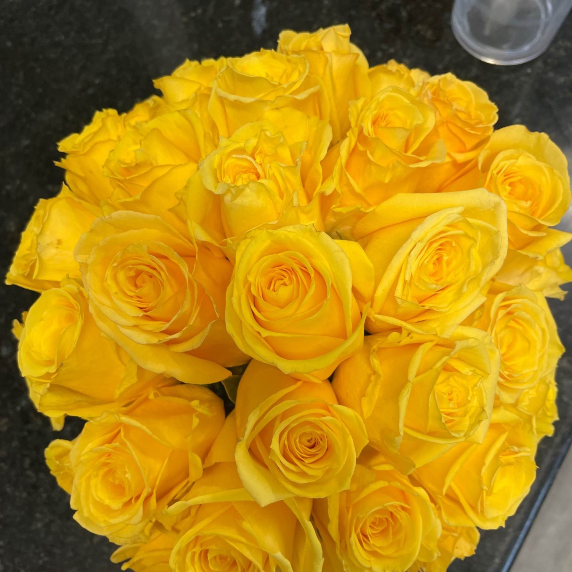 Bouquet of yellow roses on a dark countertop