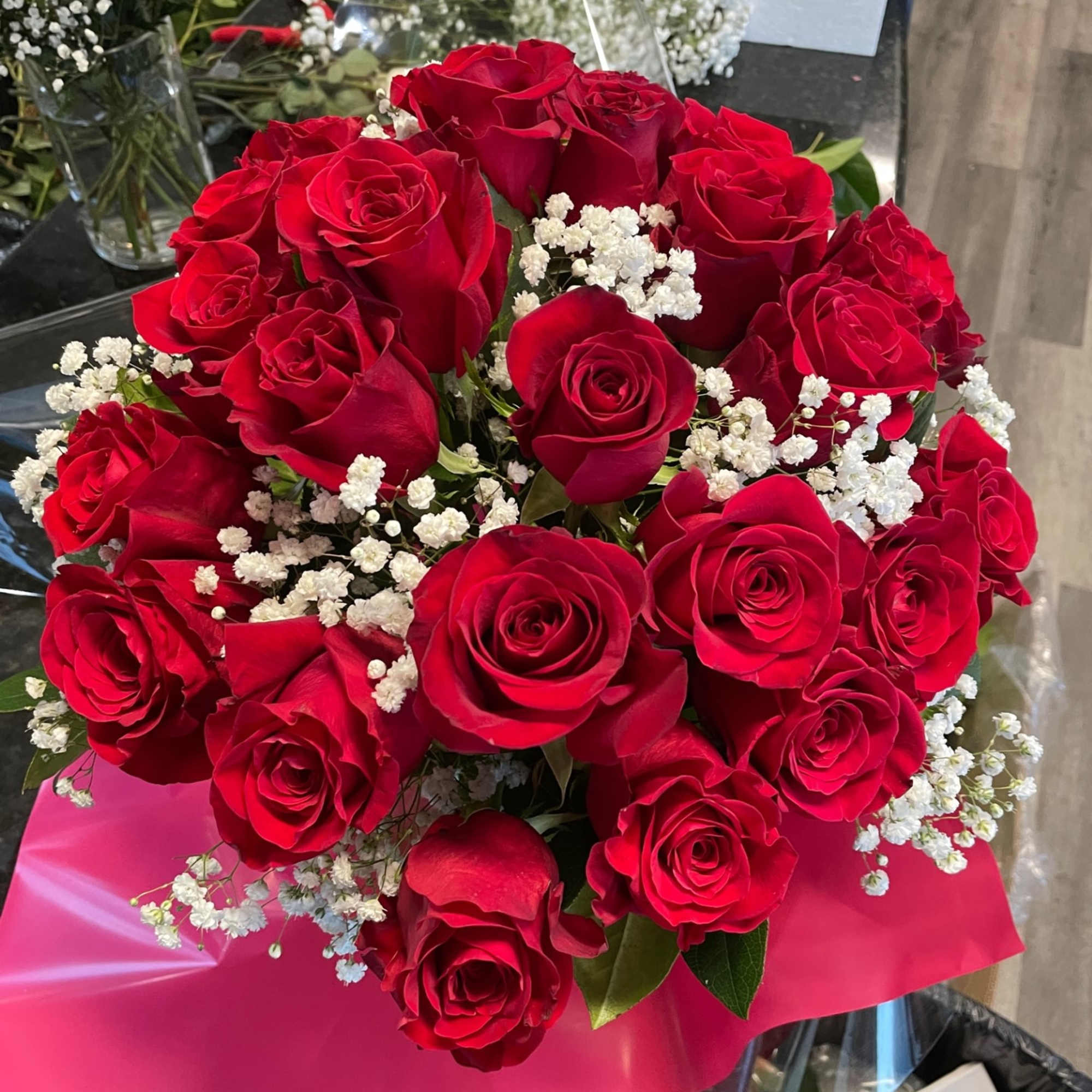 Bouquet of red roses with white baby's breath in pink wrap