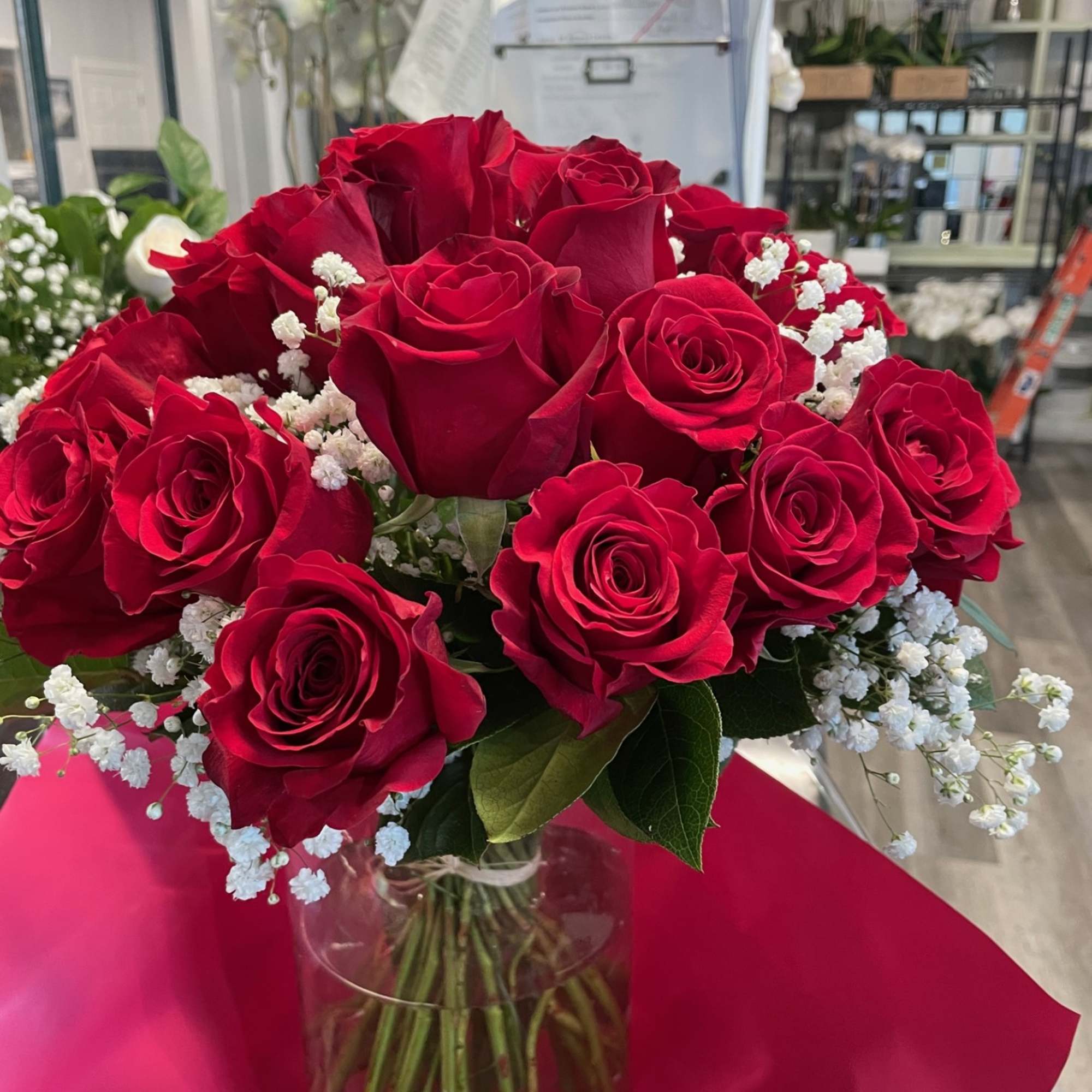 Bouquet of red roses with white baby's breath in a clear glass vase