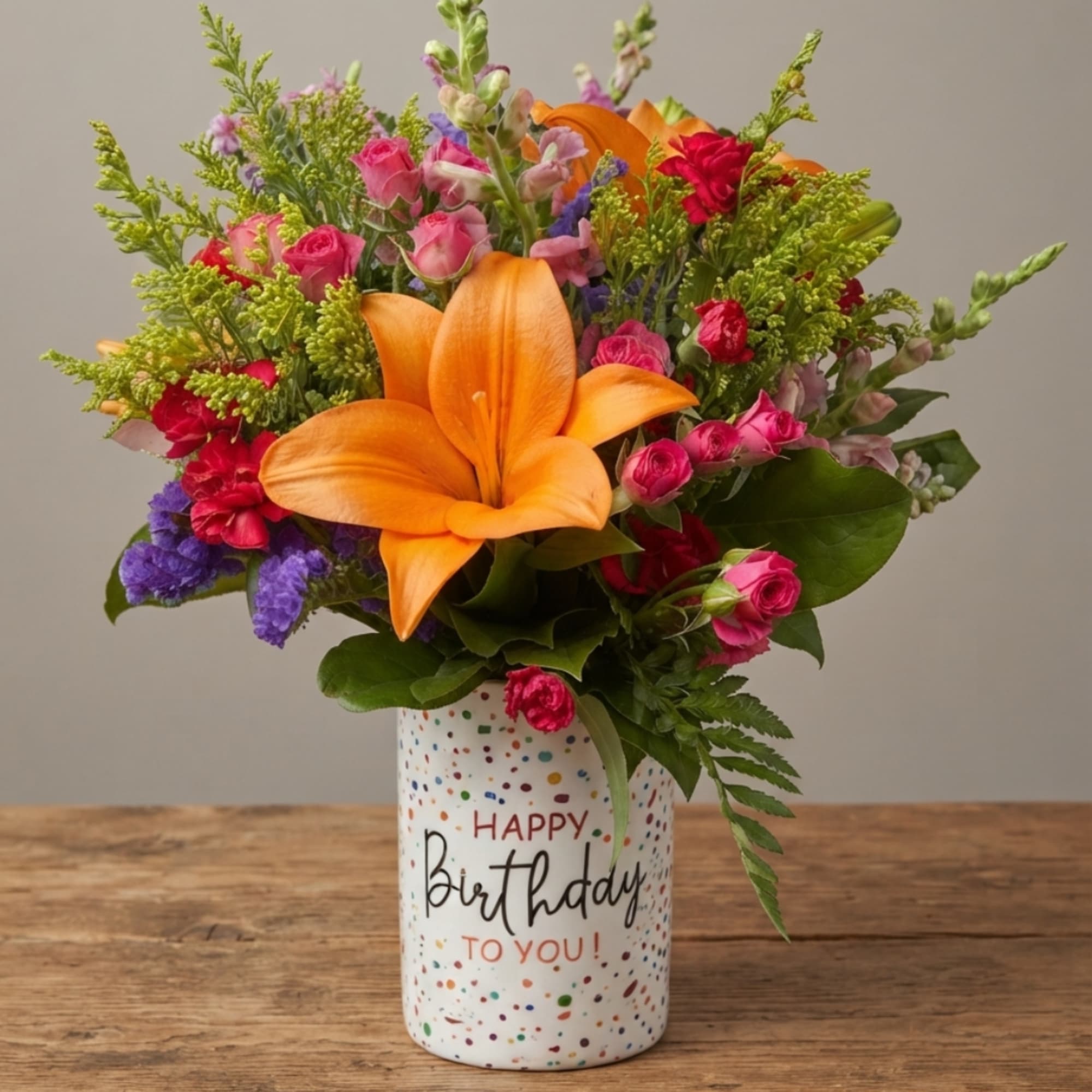 Colorful bouquet with an orange lily in a birthday vase