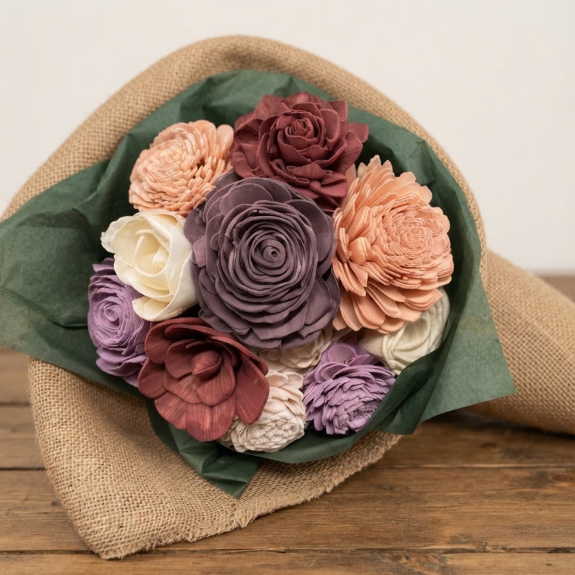 Bouquet of multicolored flowers wrapped in burlap and green paper