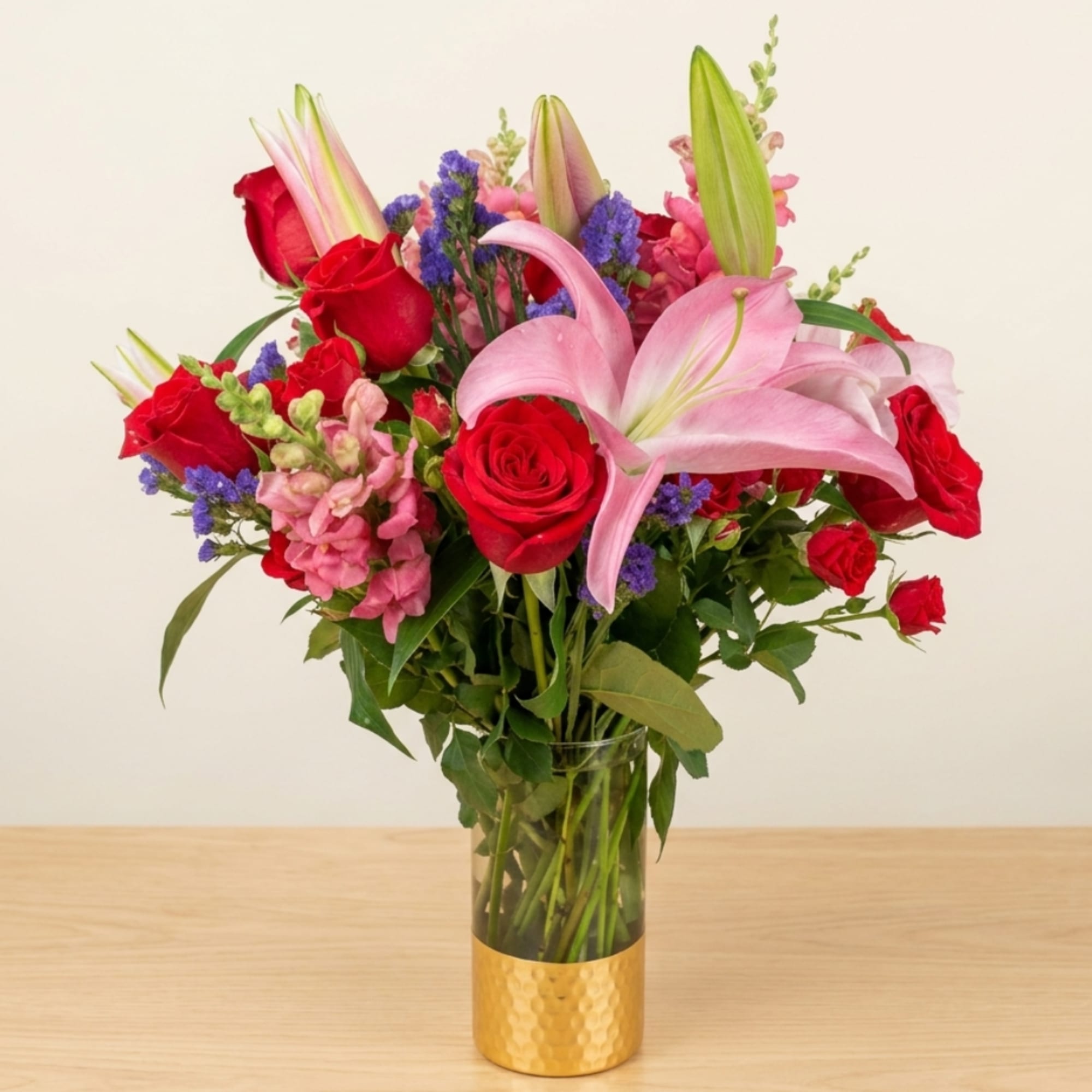 Bouquet of red roses and pink lilies in a glass vase