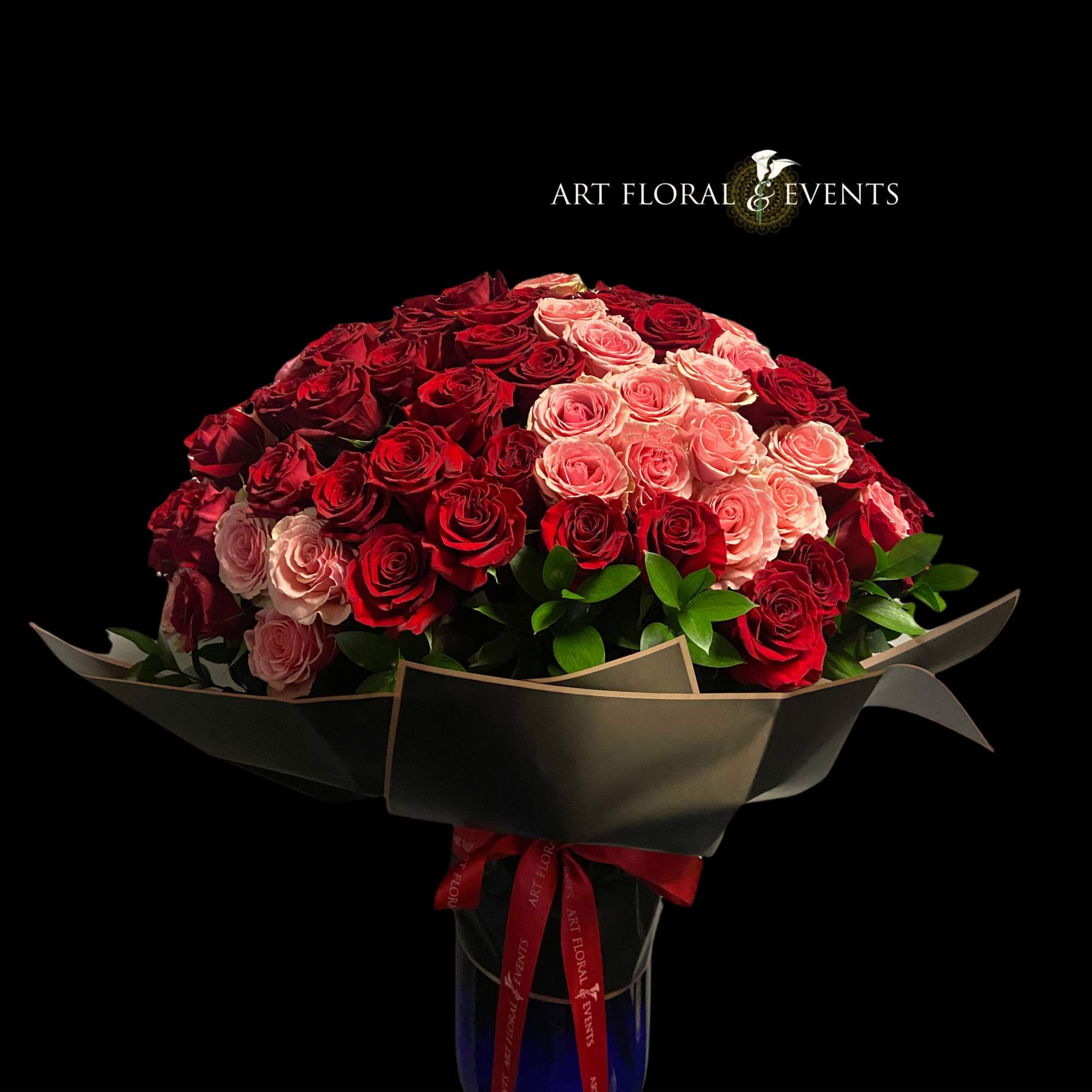 Bouquet of red and pink roses wrapped in dark paper