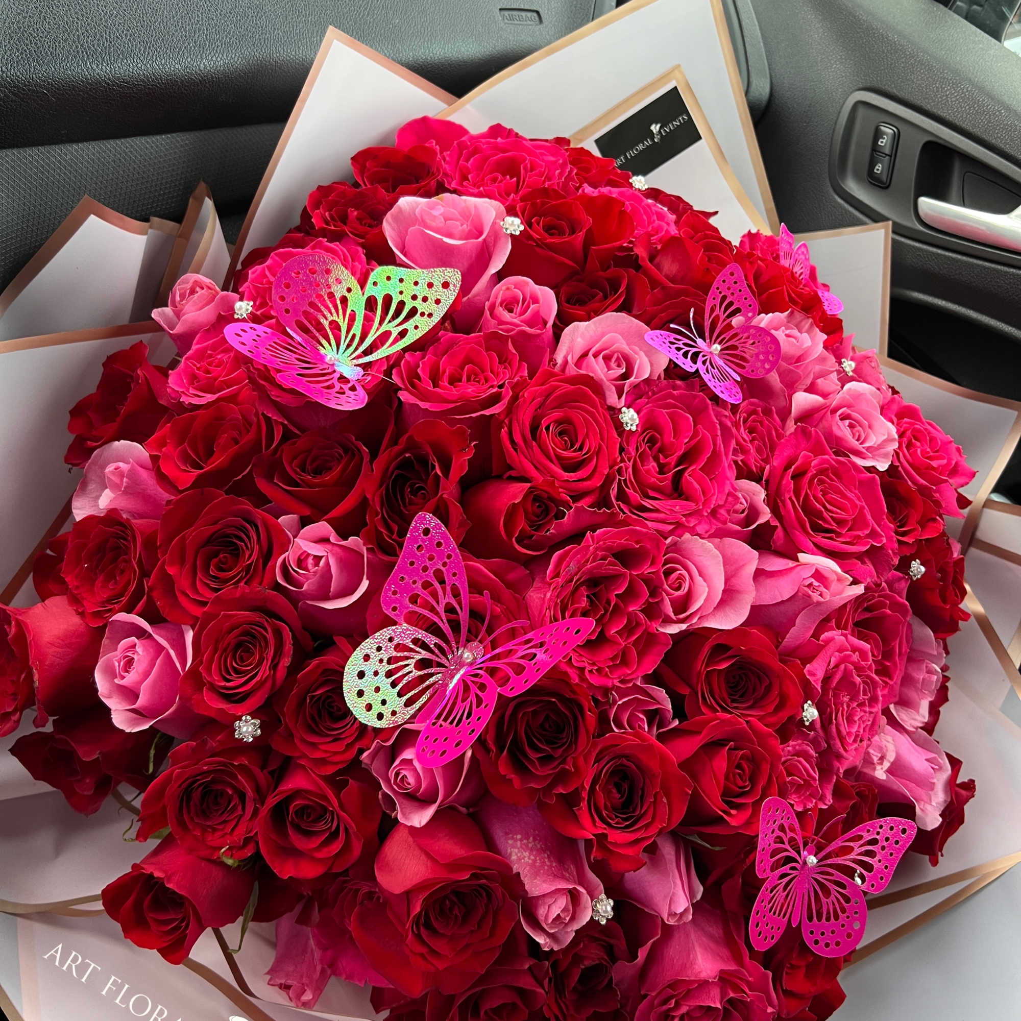 Large bouquet of red and pink roses with butterfly decorations