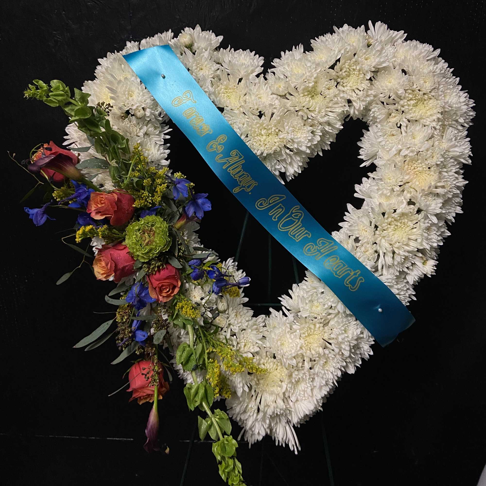 Heart-shaped floral wreath with white chrysanthemums and mixed colorful flowers