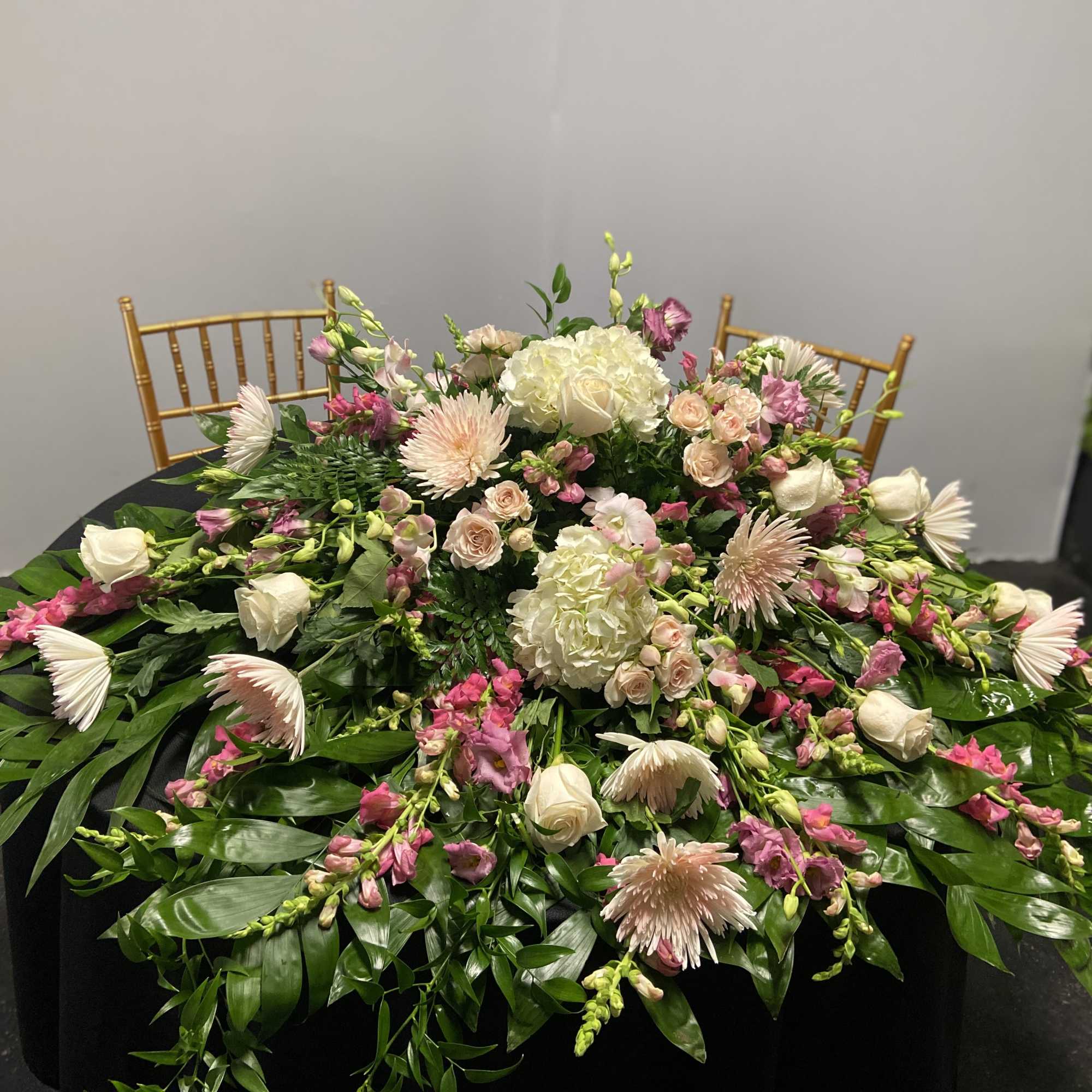 Large floral centerpiece with pink and white blooms on a table