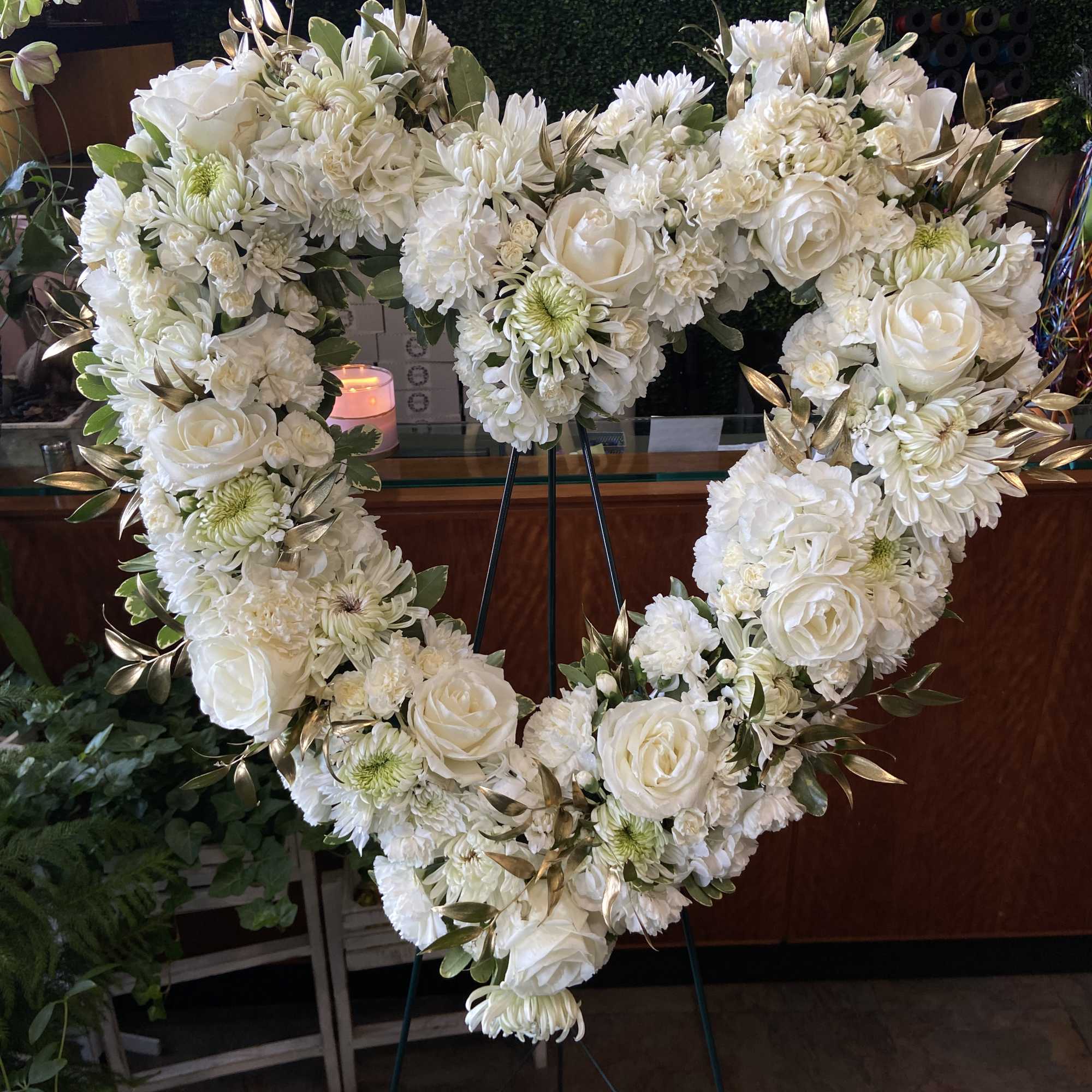 Heart-shaped white floral wreath on a stand