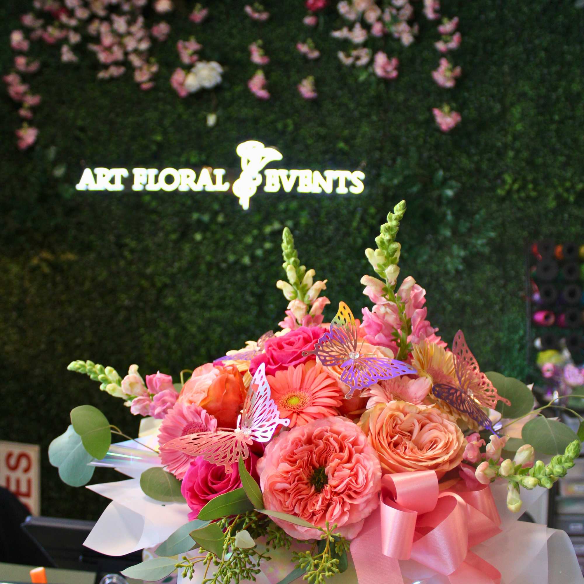 Pink and peach flower bouquet in a white box with a ribbon