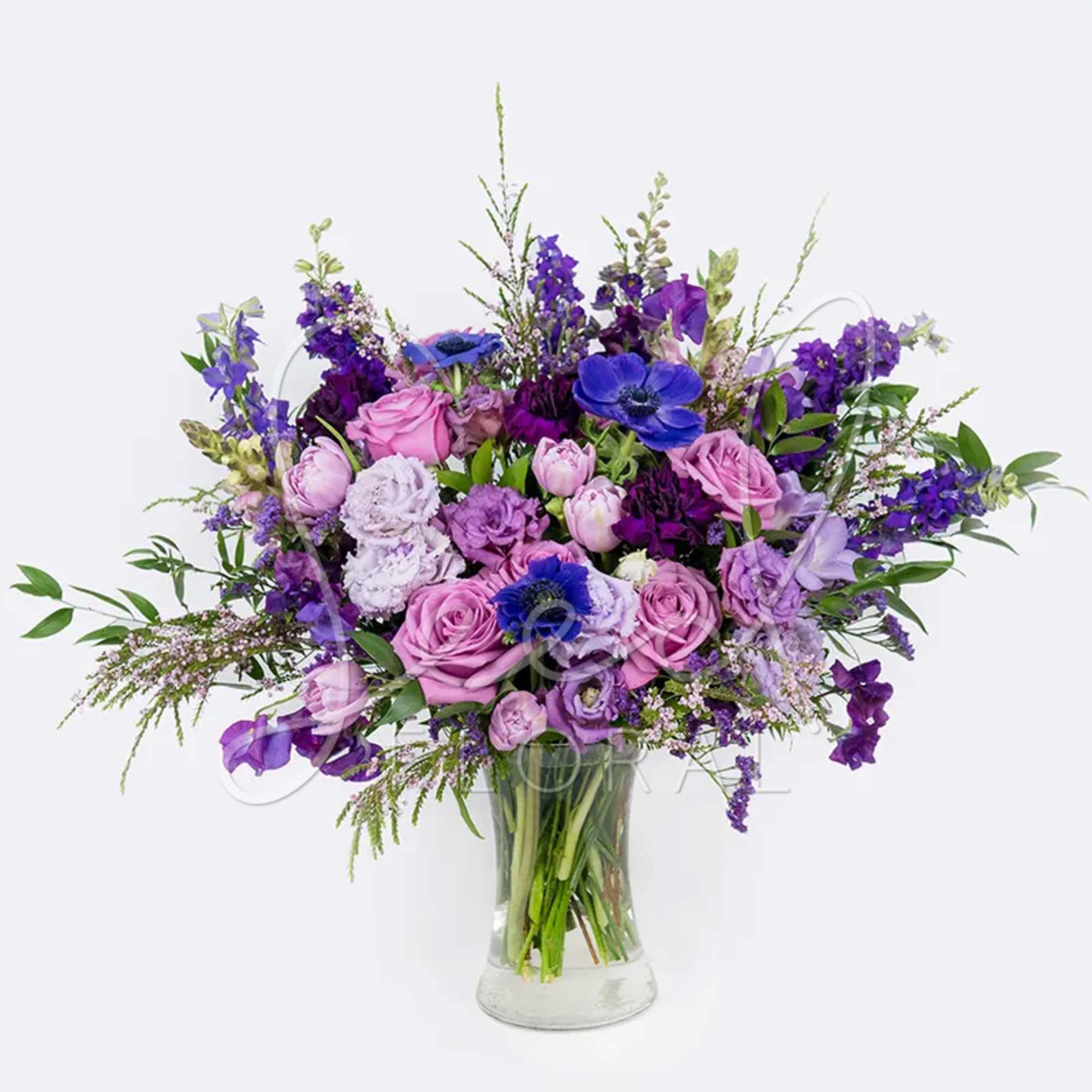 Purple and pink mixed bouquet in a clear glass vase