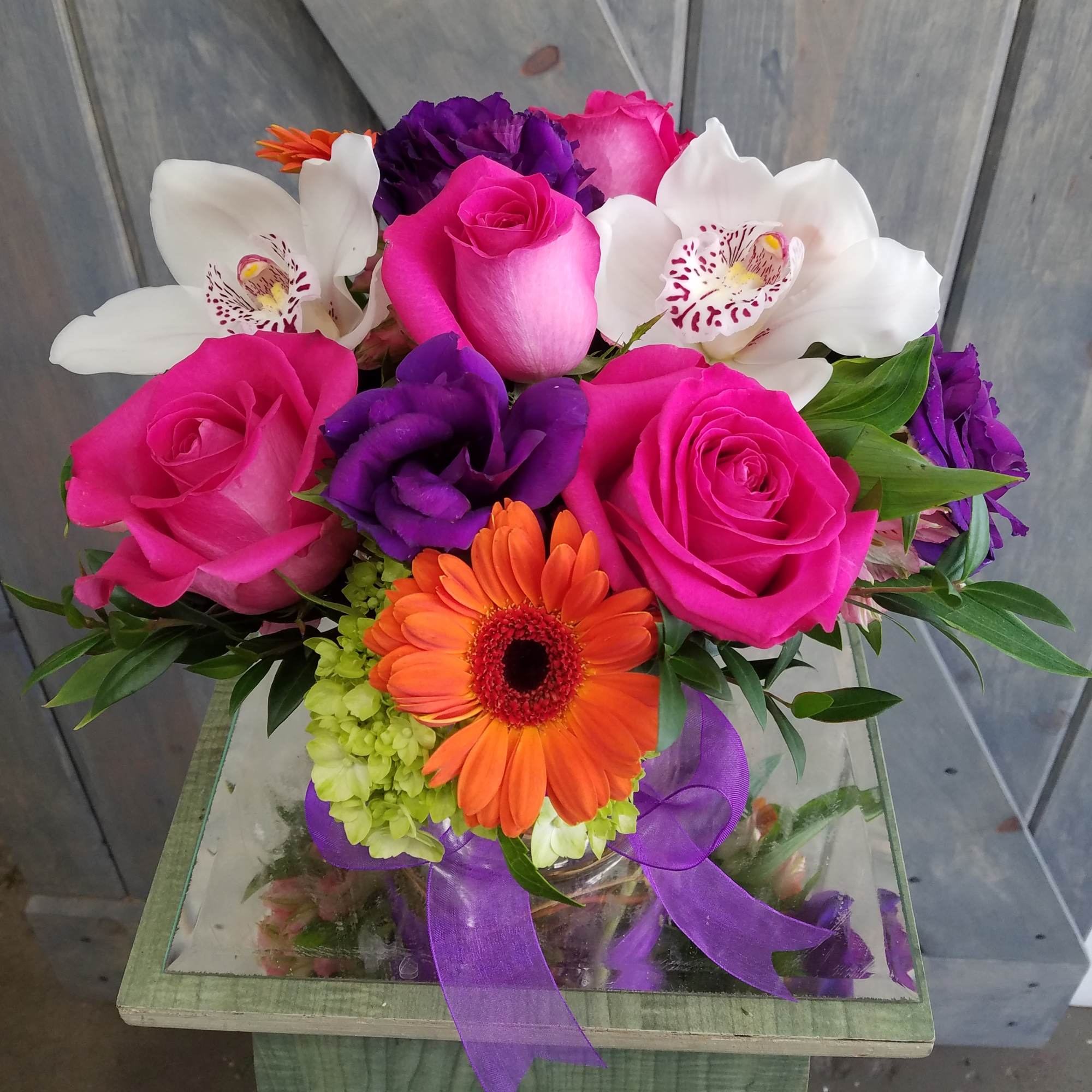 Bouquet of pink roses, white orchids, and an orange gerbera daisy