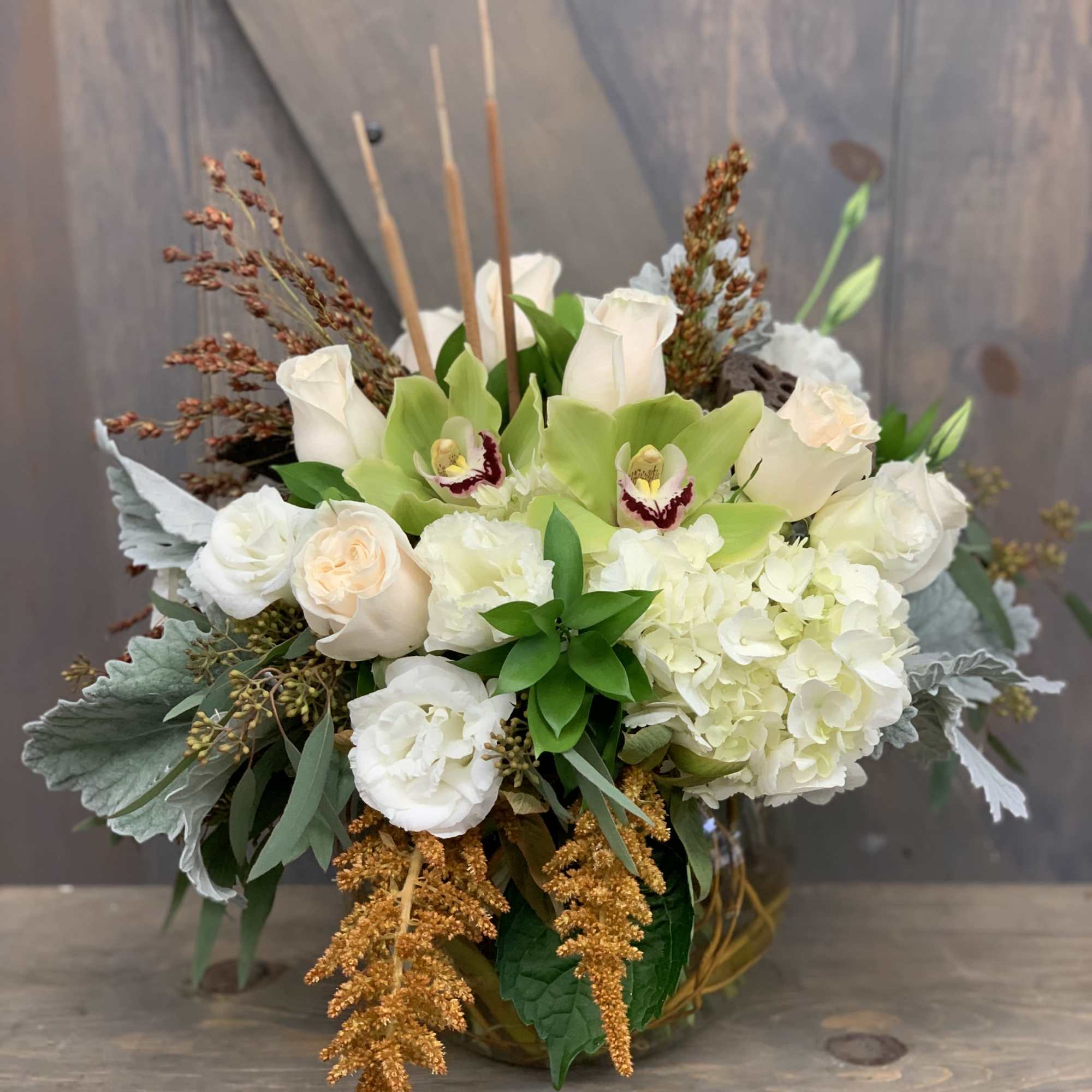 White roses and green orchids in a low vase arrangement