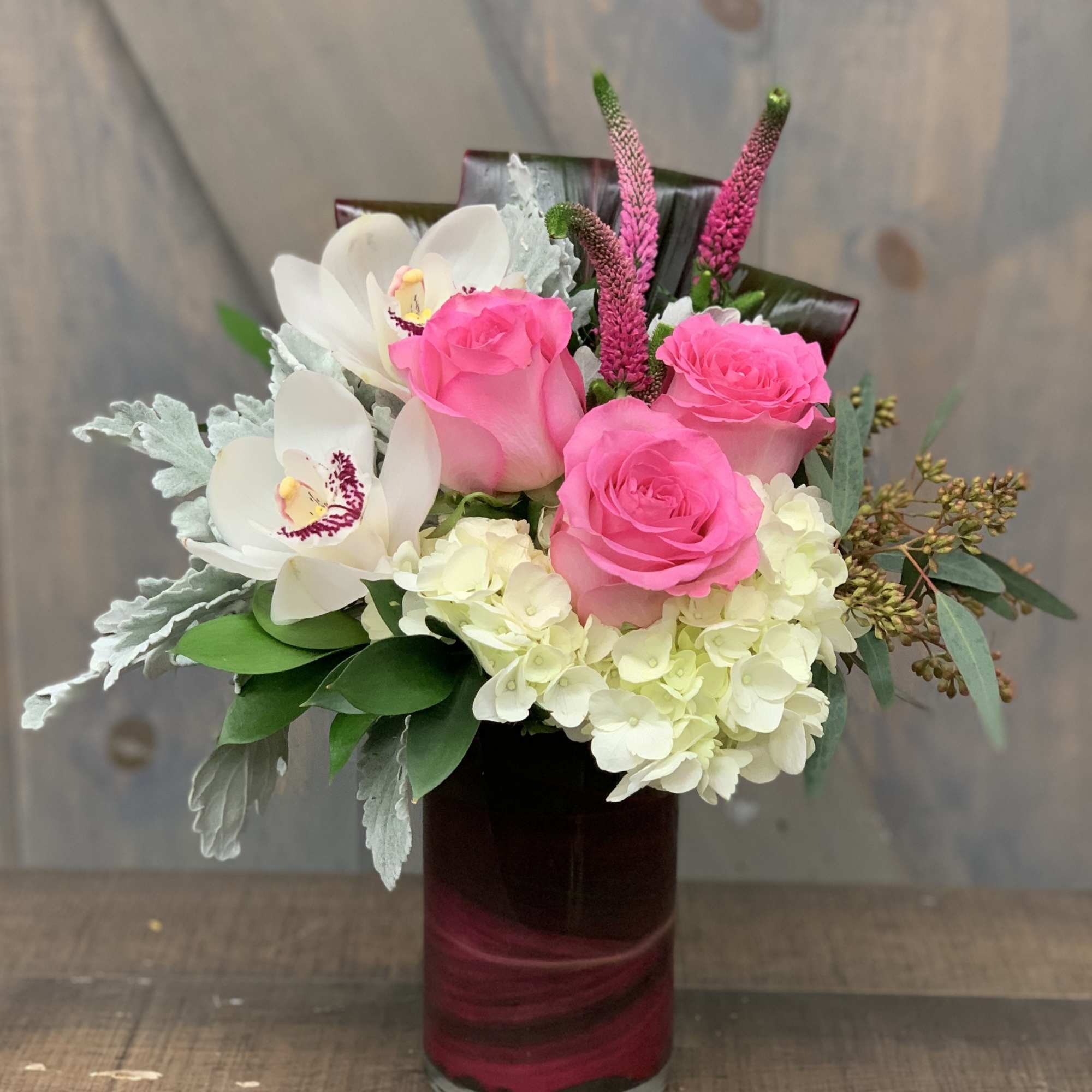 Pink roses and white orchids arranged in a glass vase