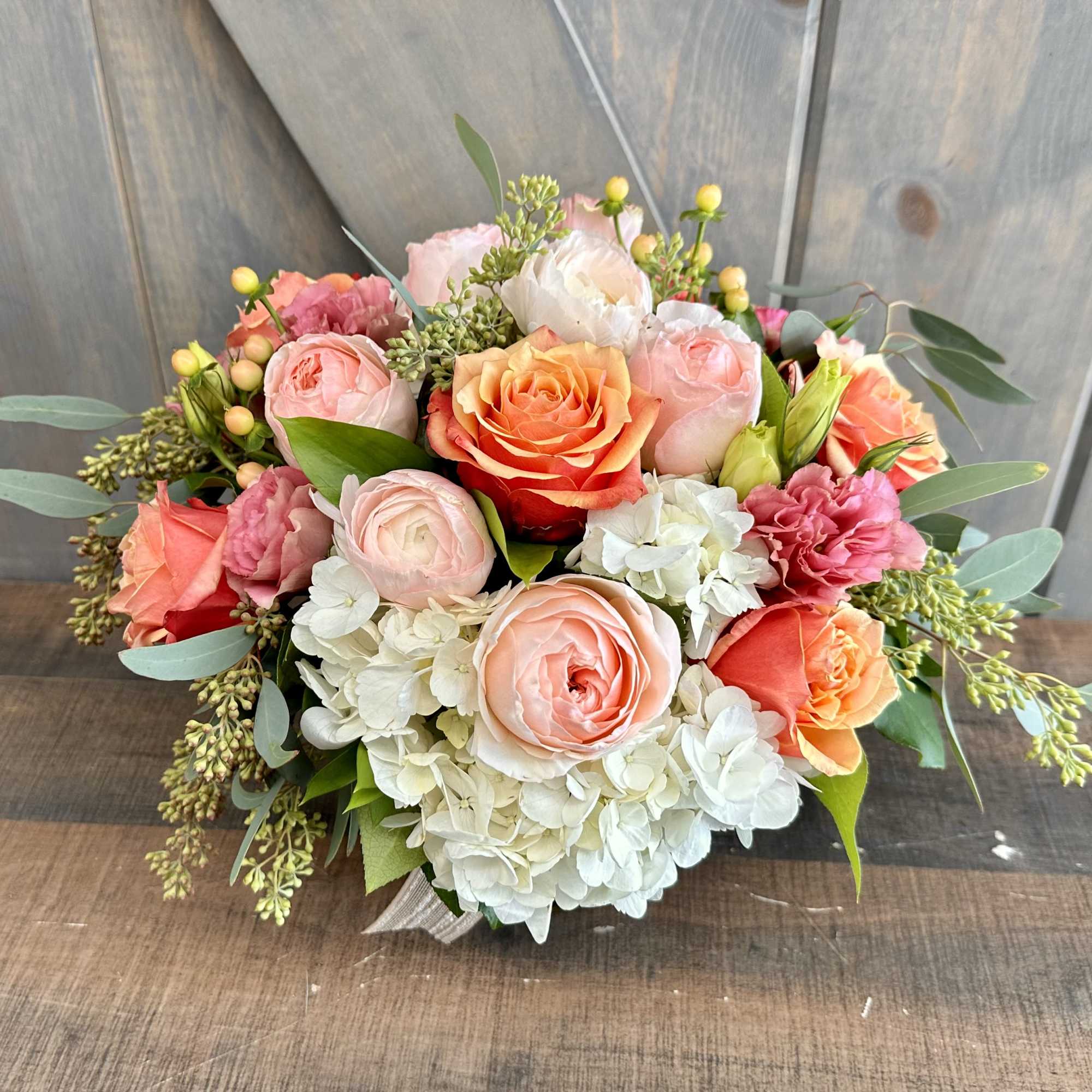 Bouquet of peach and pink roses with white hydrangeas