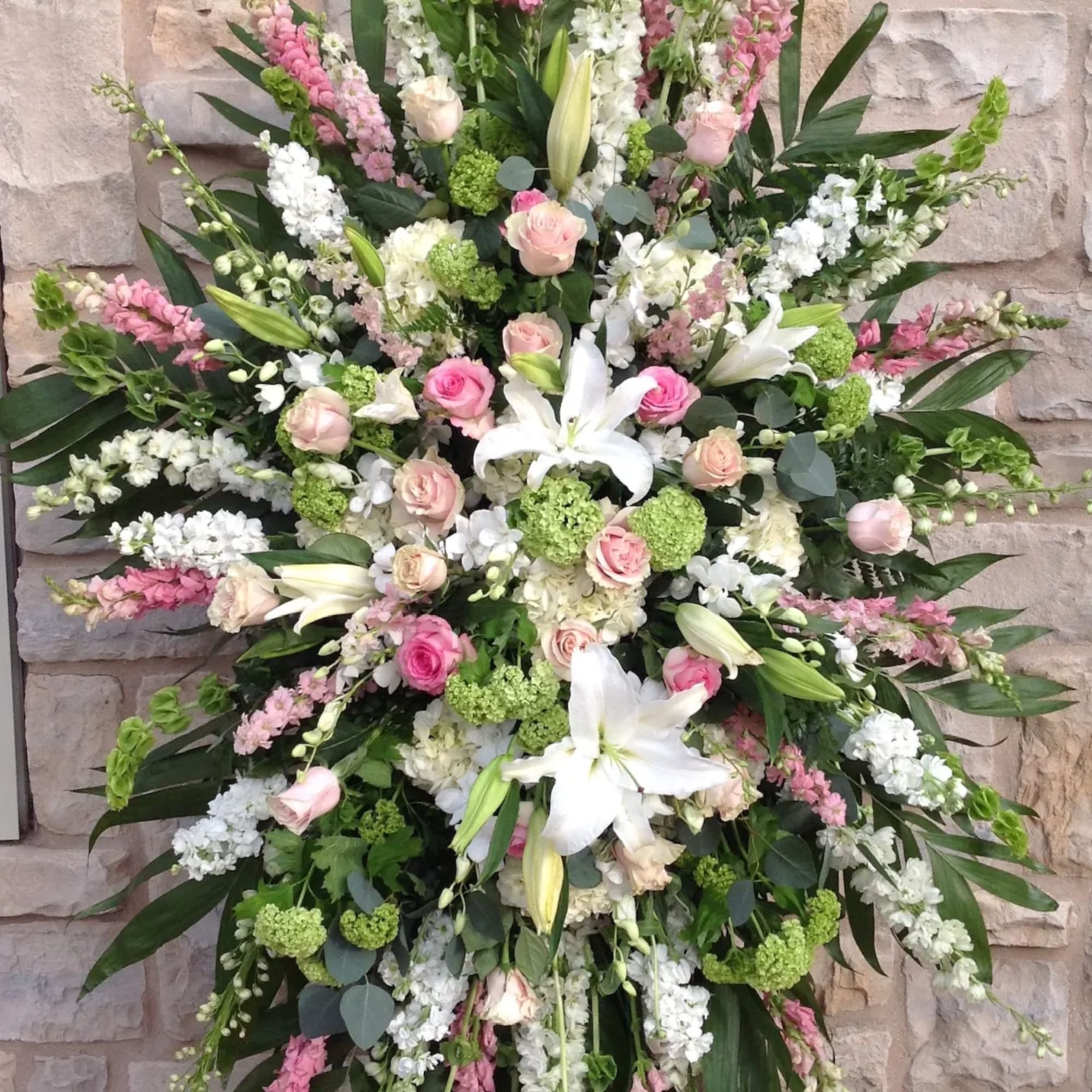 Large standing spray of pink and white flowers with lilies and roses