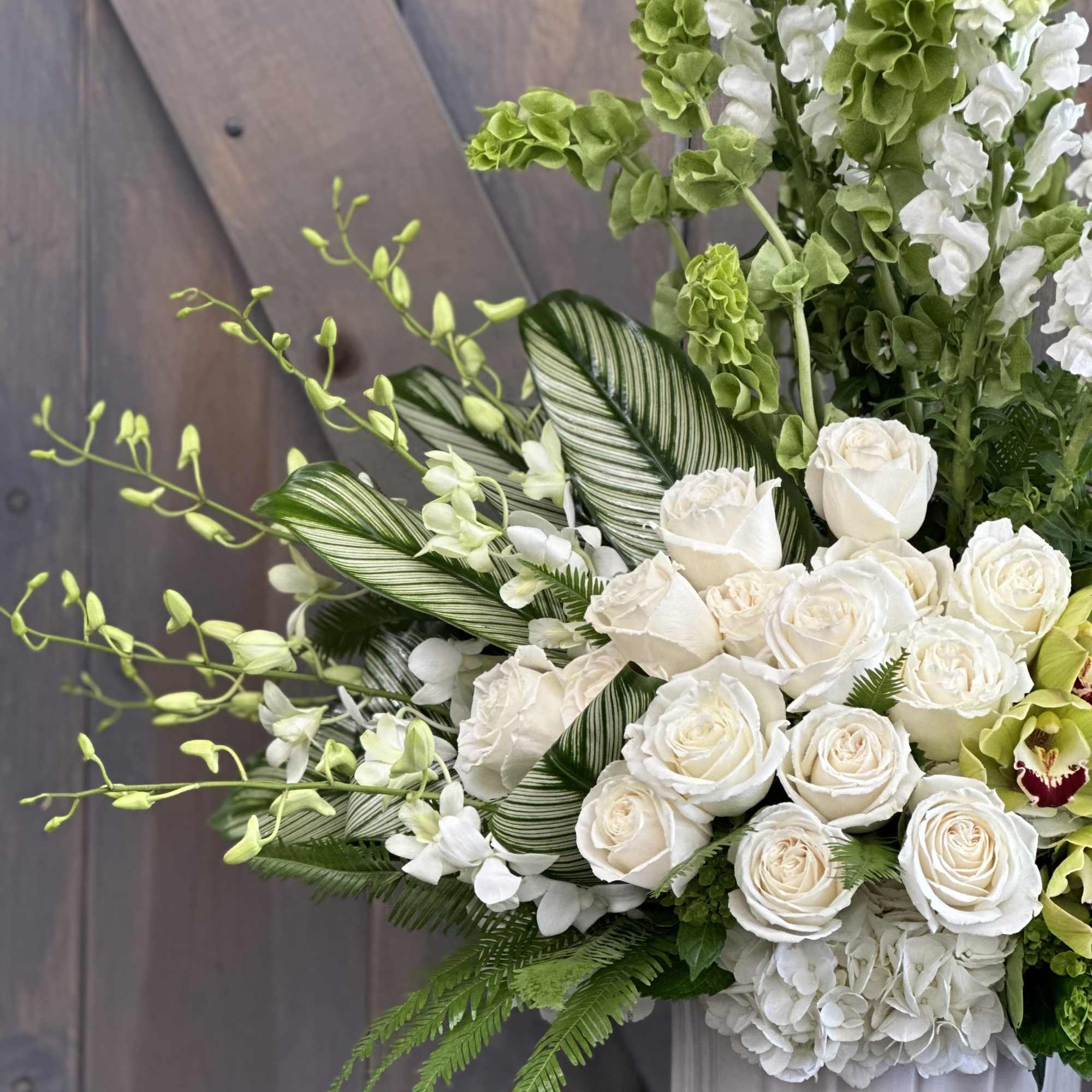 White roses and green-white blooms in a white vase