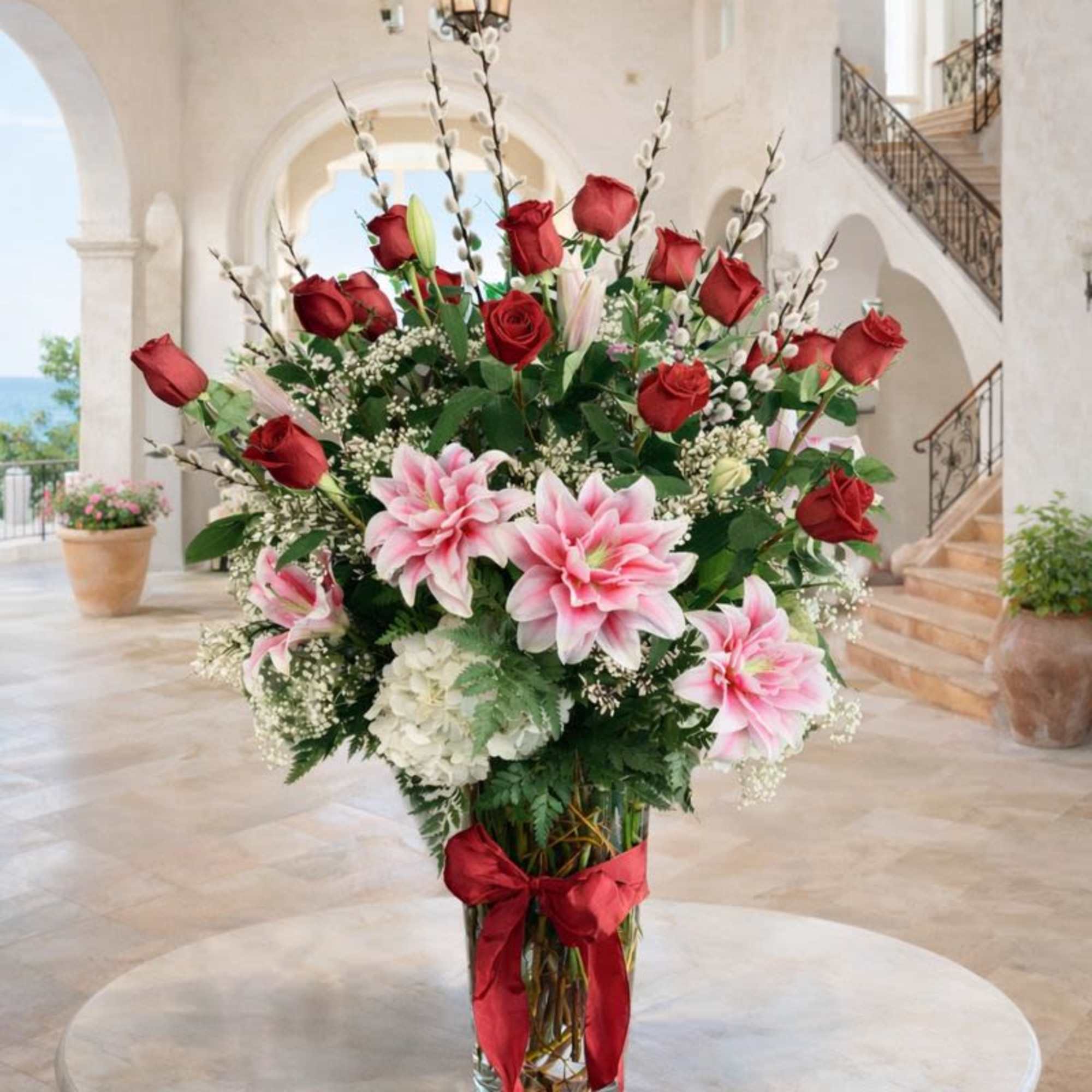 Tall vase arrangement with red roses and pink lilies