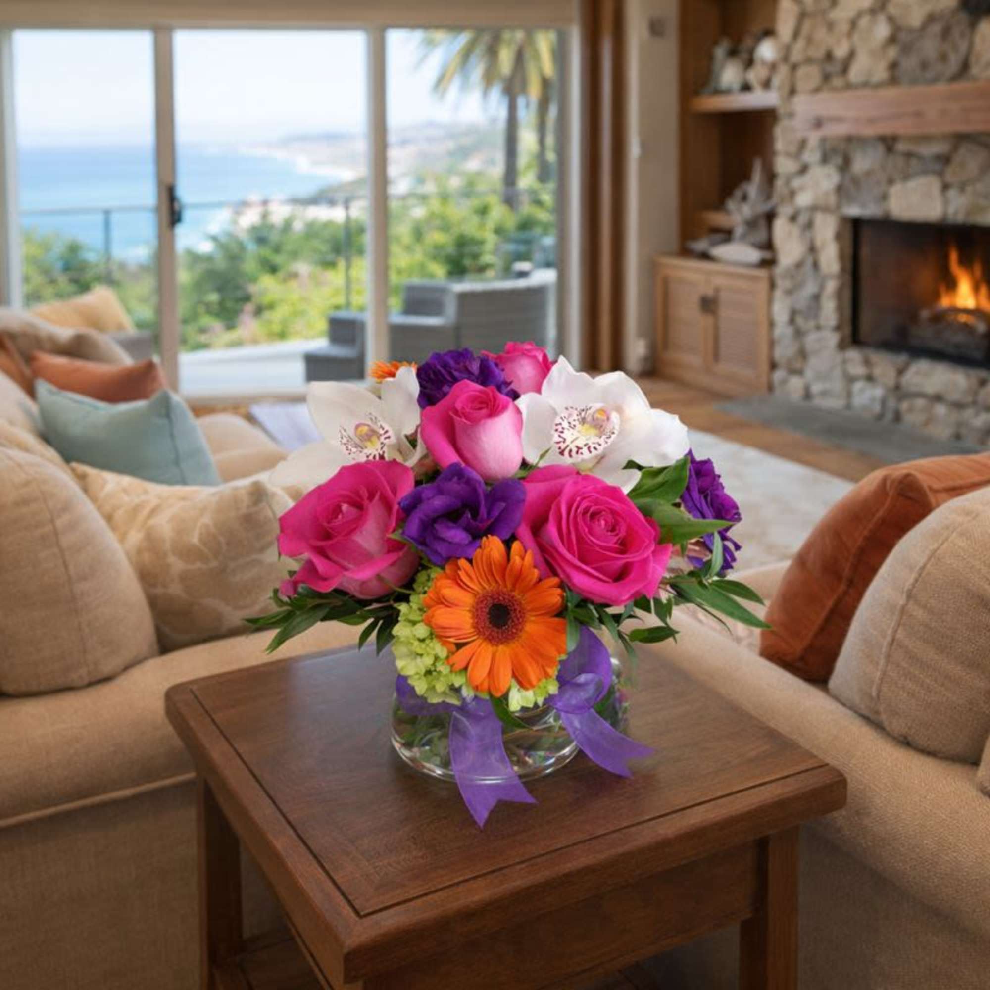 Pink and purple flower arrangement in a glass vase on a table