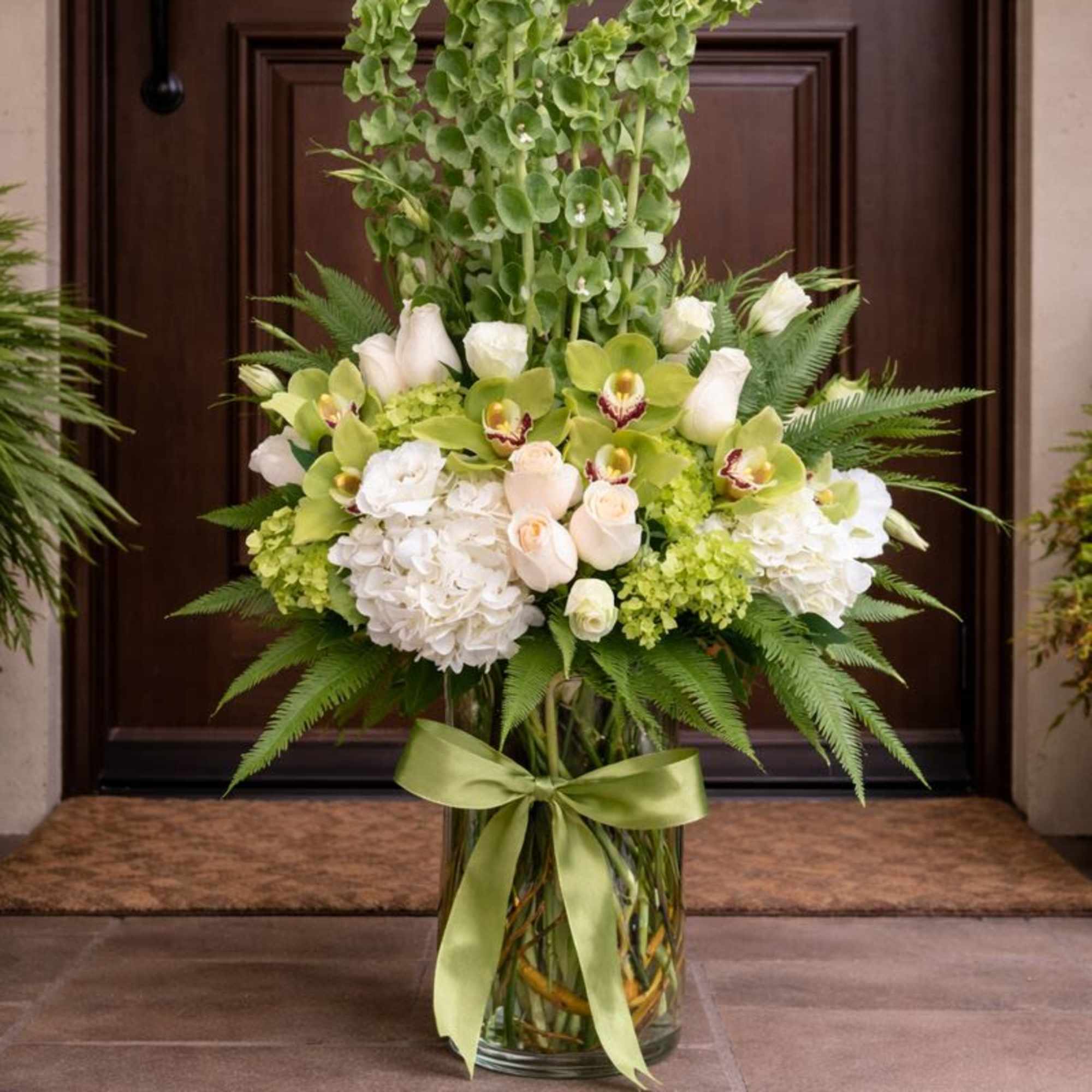 This elegant and sophicated floral display includes Umbrella fern, White hydrangea, White