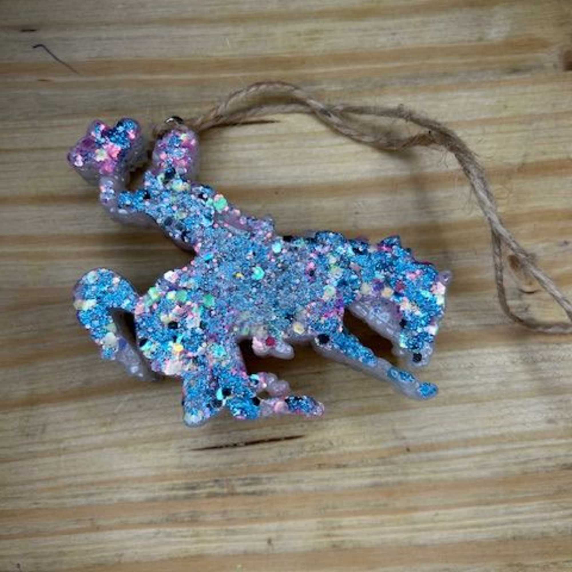 Glitter-covered unicorn ornament with a hanging string
