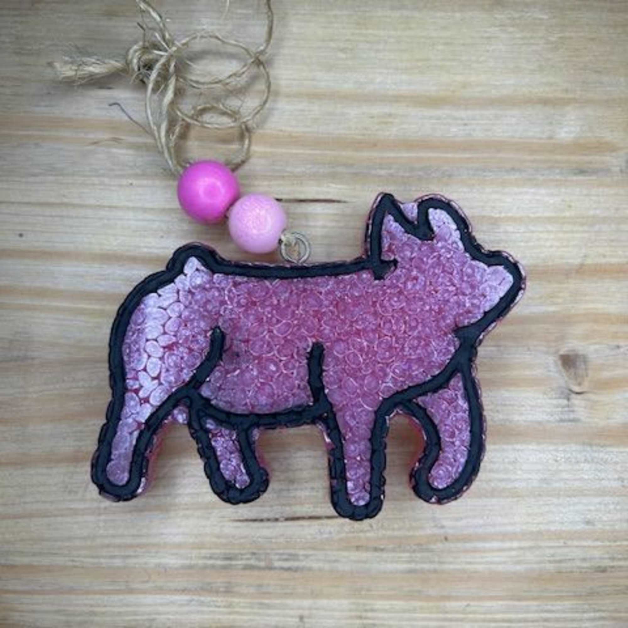 Pink pig-shaped ornament with a twine hanger and beads