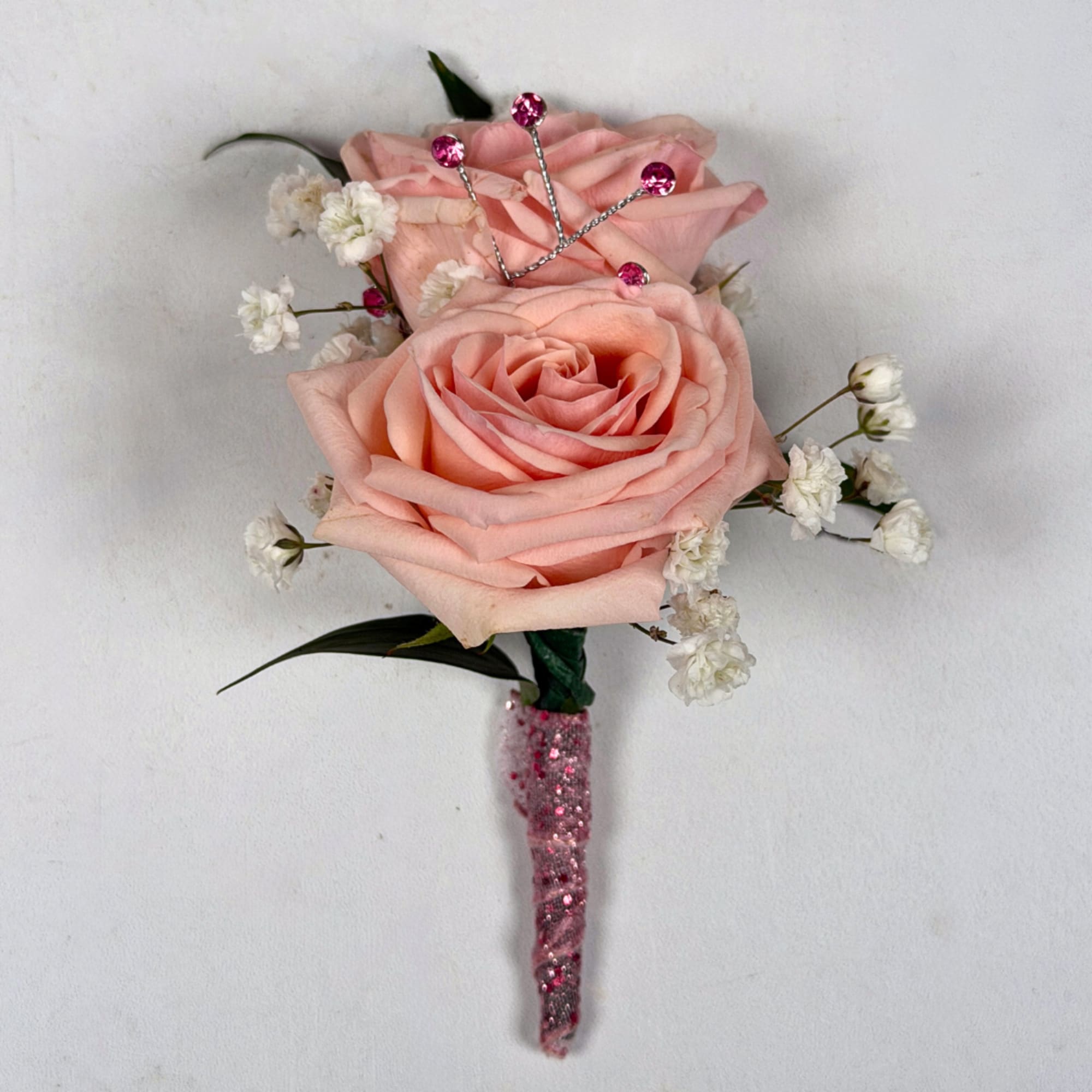 Two pale blush roses sit snugly together in this Rose Quartz boutonniere