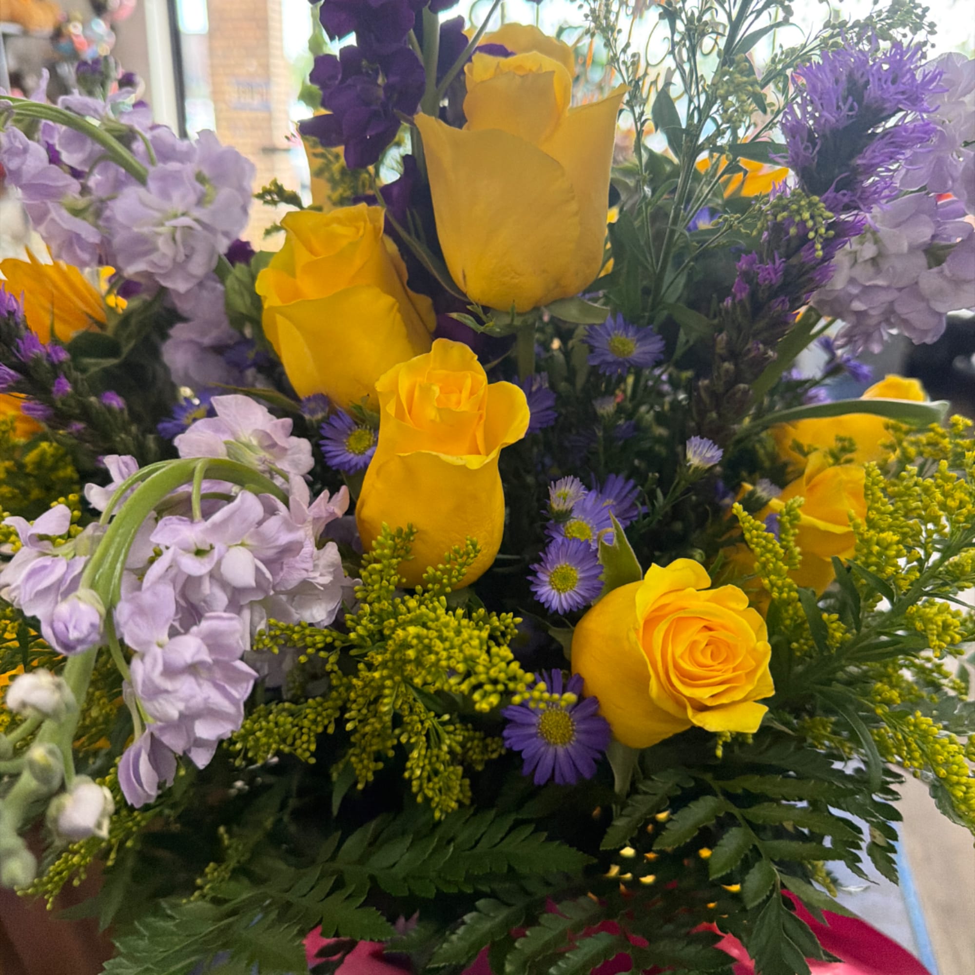 Bouquet of yellow roses, purple flowers, and lavender blooms