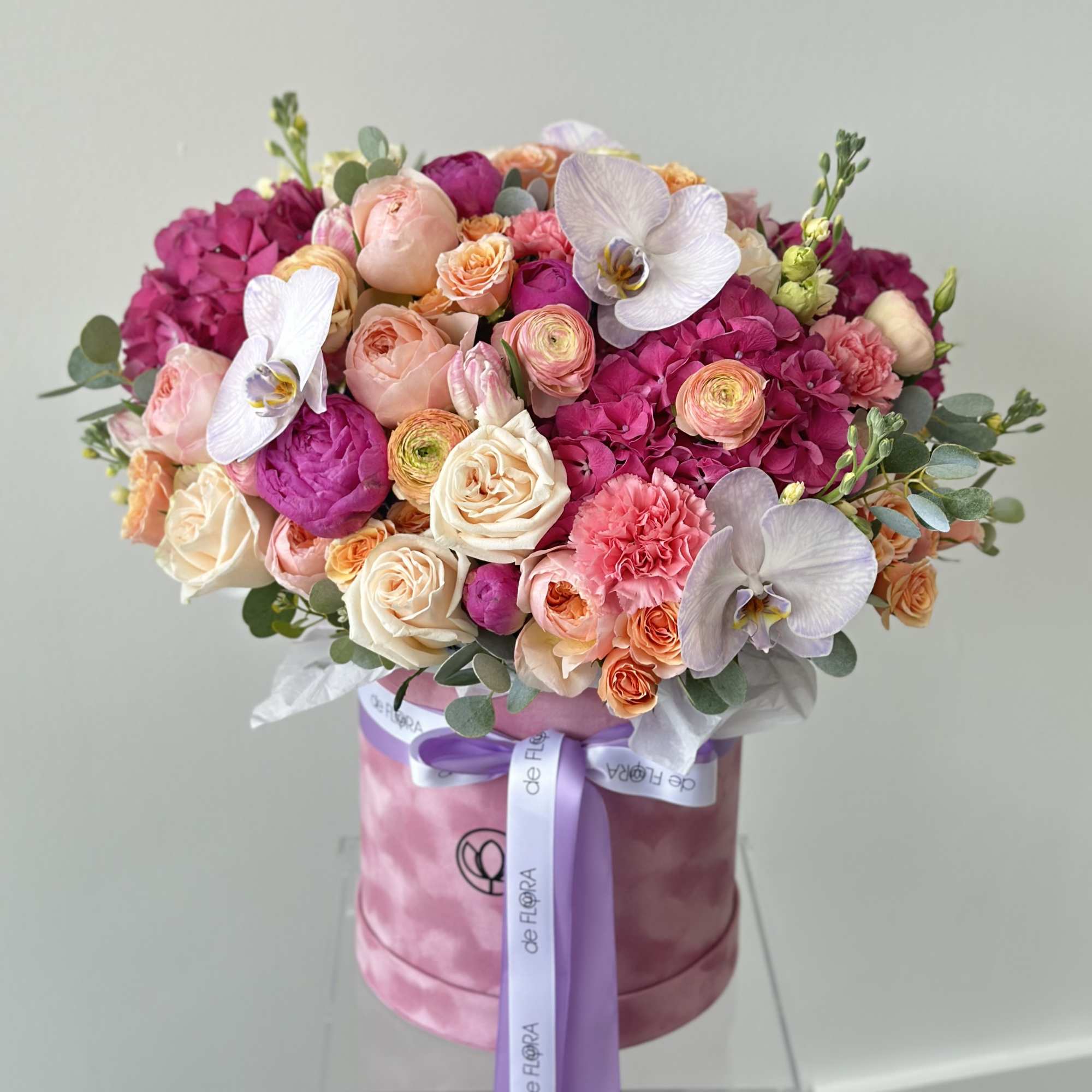 Pink and peach bouquet in a pink hatbox with a lavender ribbon