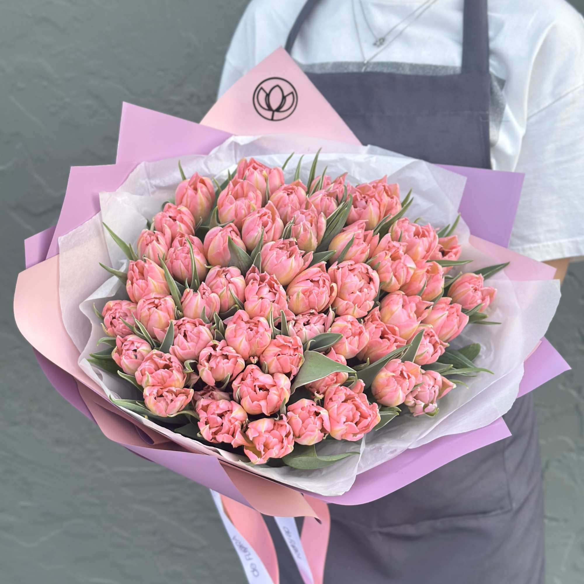 Large bouquet of pink tulips wrapped in pink and white paper