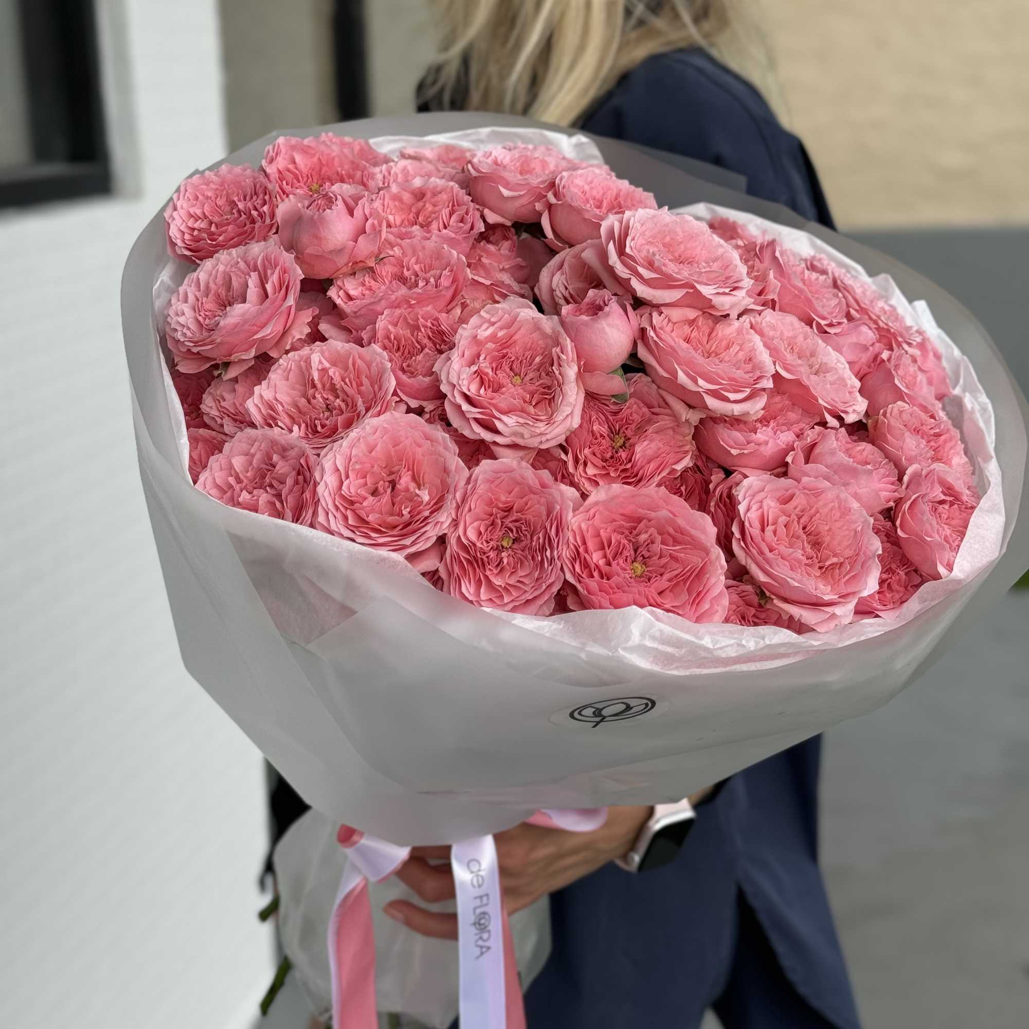 Large bouquet of pink roses wrapped in white paper