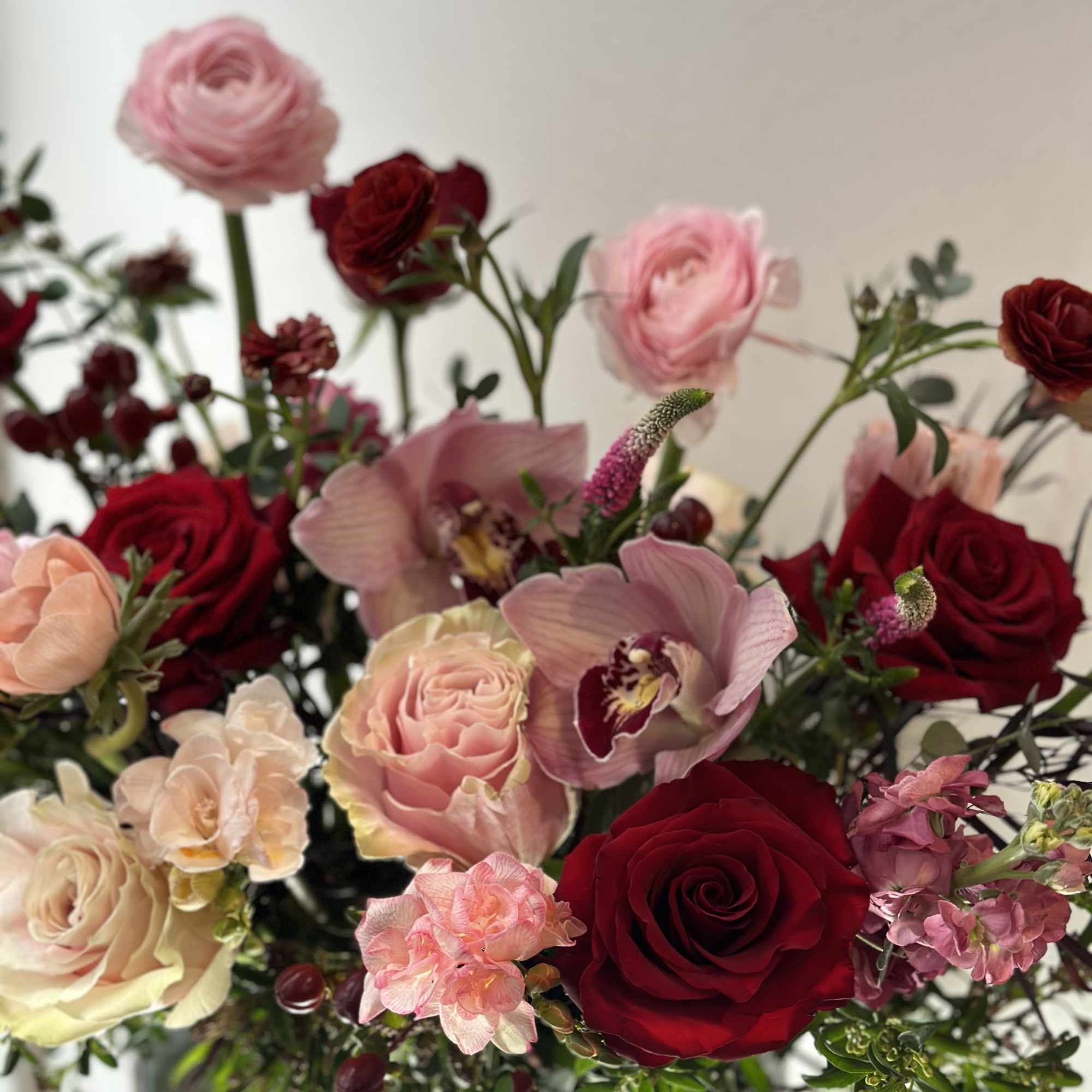Bouquet of red and blush roses with pink orchids