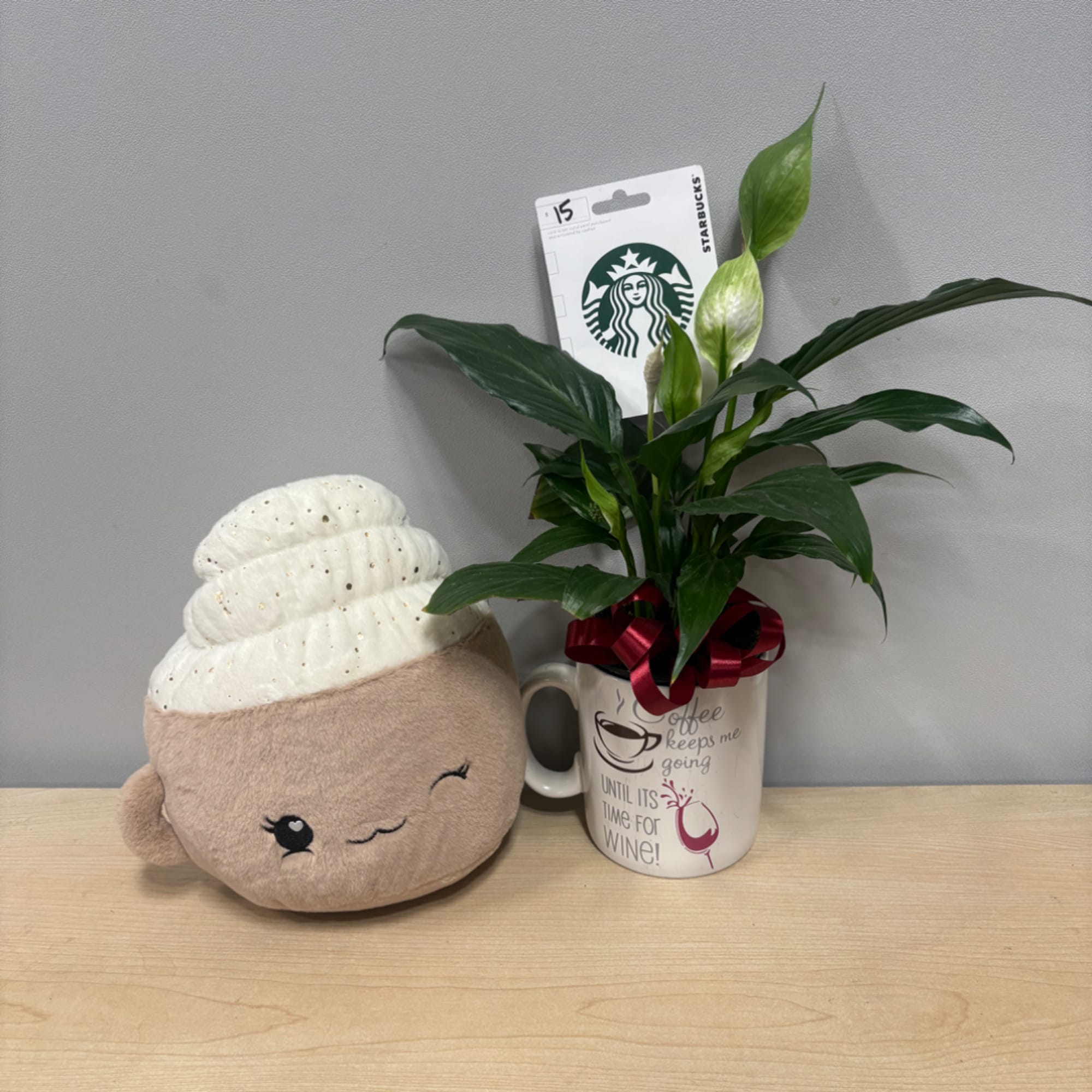 Potted peace lily in a mug beside a plush coffee cup toy