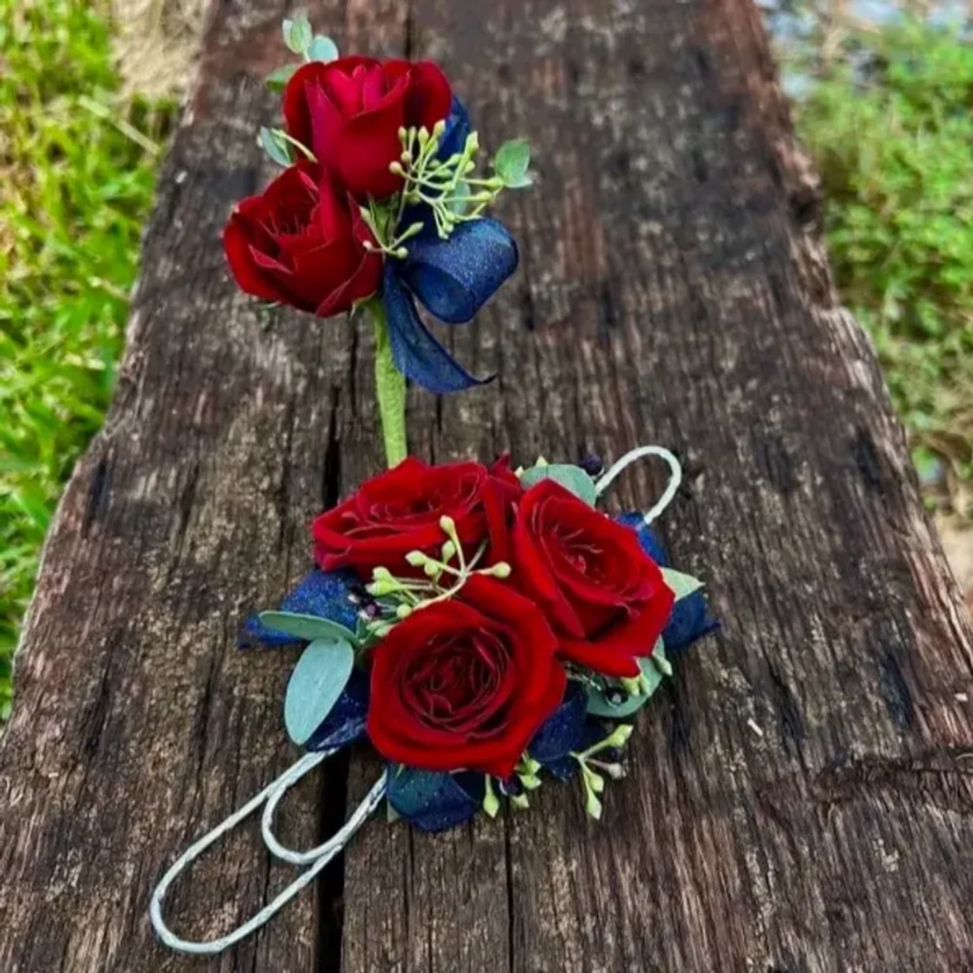 Red rose corsage and boutonniere with blue ribbon accents
