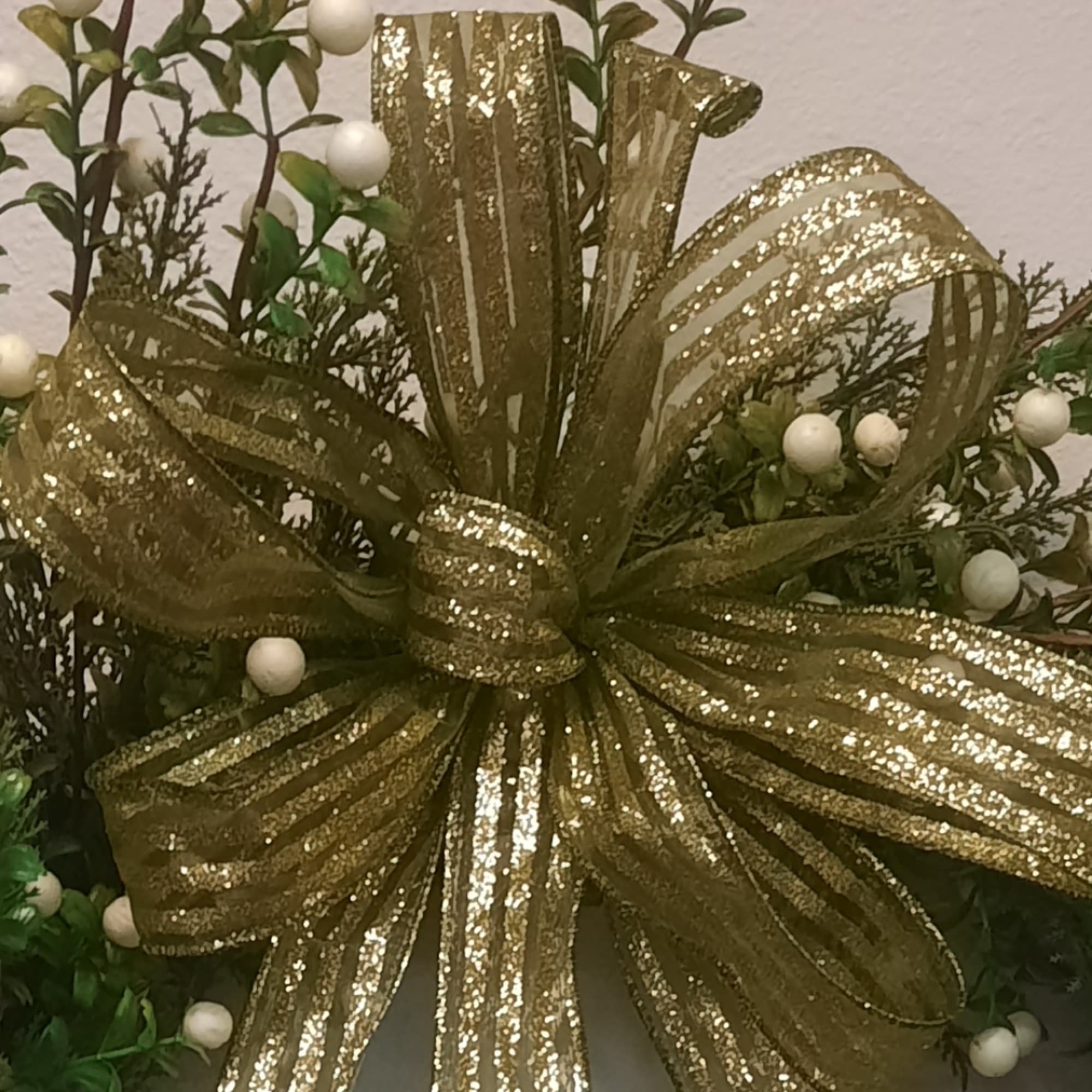 Gold glitter ribbon bow with white berry accents and greenery
