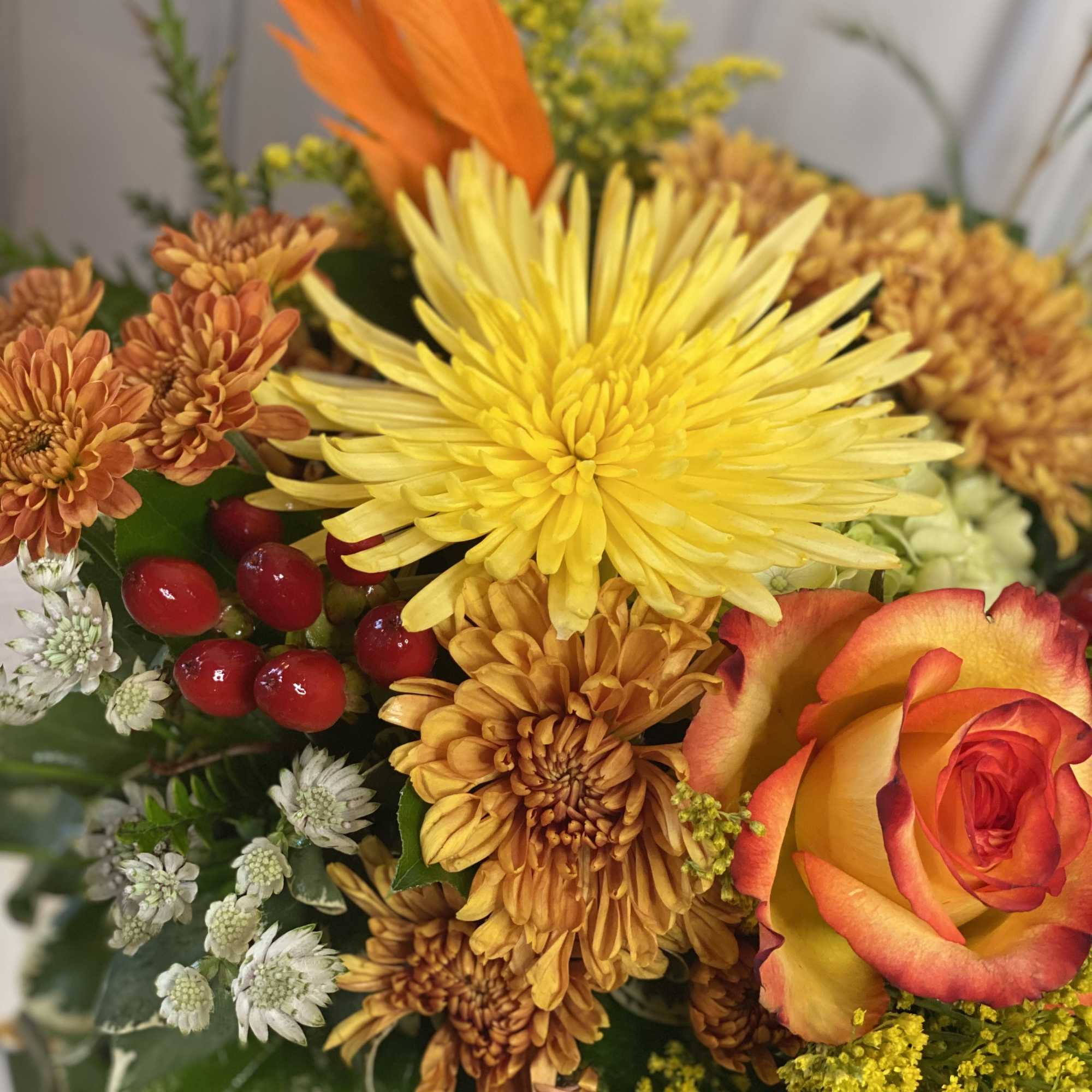 Mixed bouquet with yellow and orange chrysanthemums and a red-yellow rose