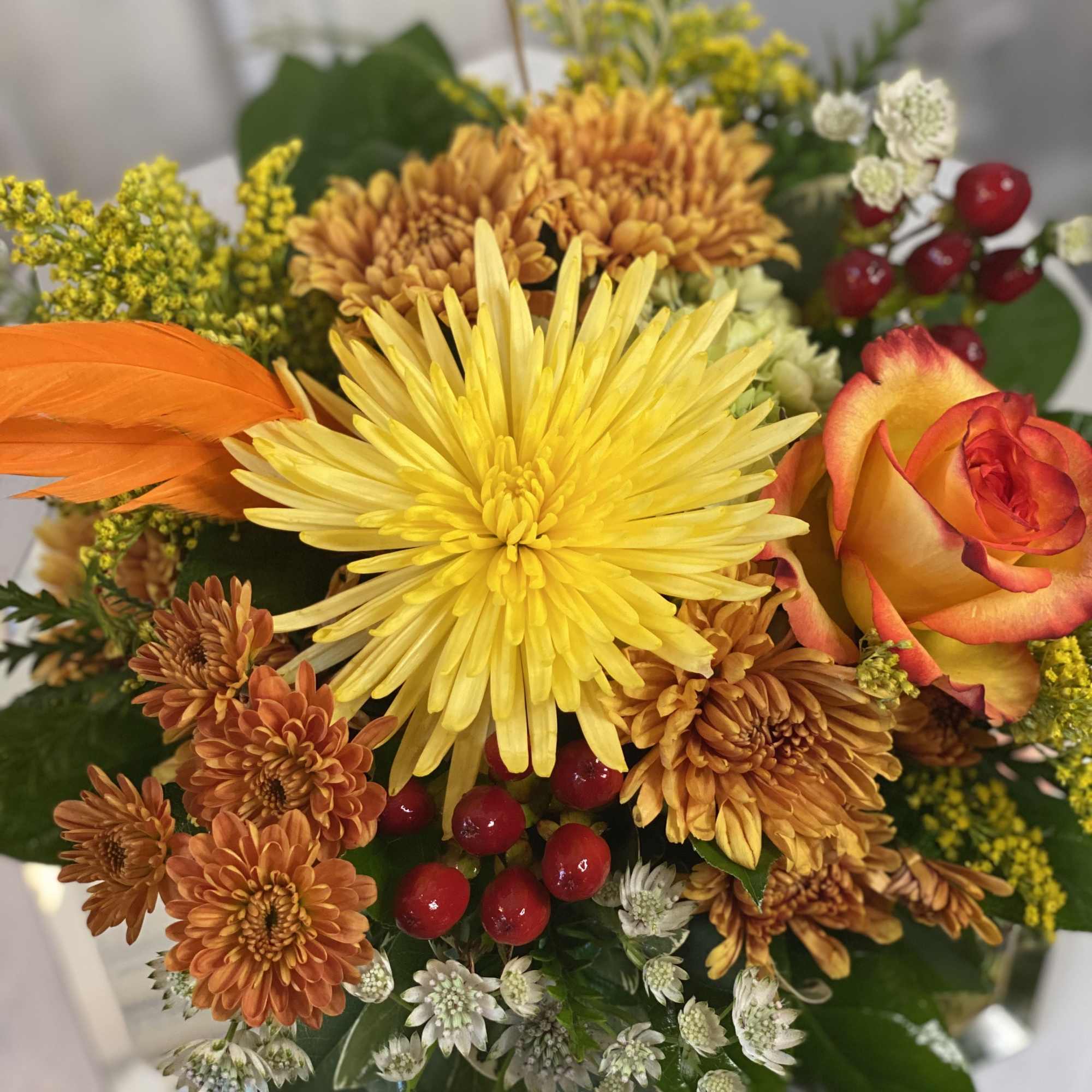 Bouquet of yellow and orange flowers with a red-orange rose